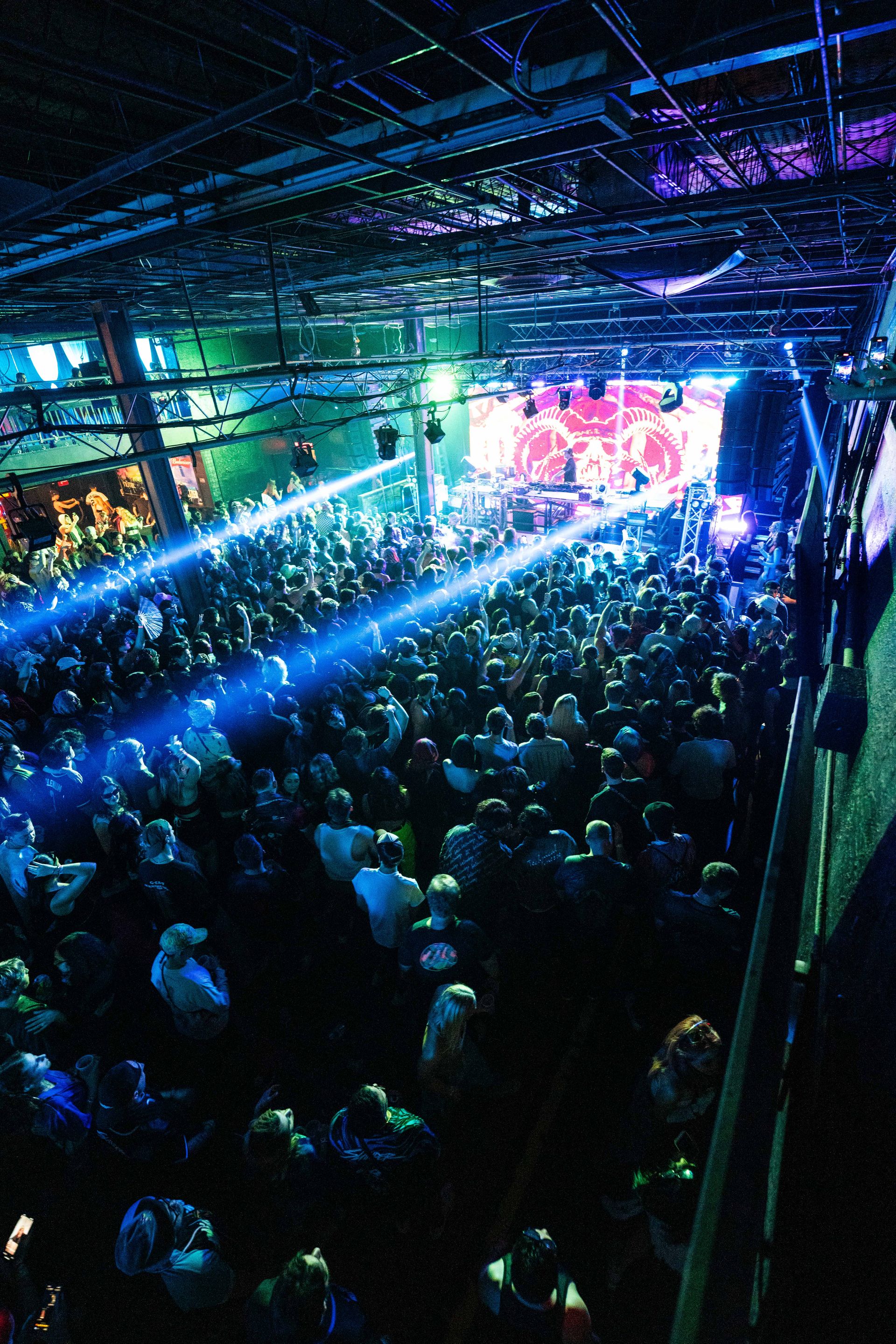 A large crowd of people are watching a band on stage