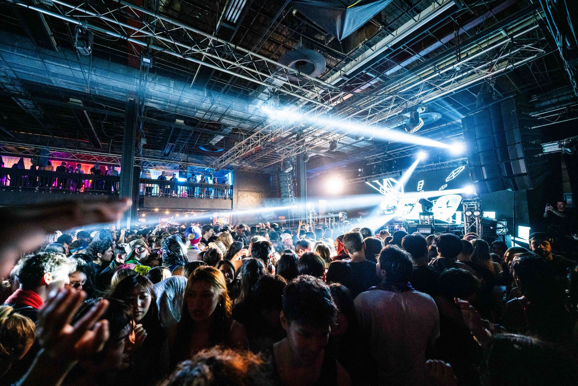 A crowd of people are standing in front of a stage at a concert.