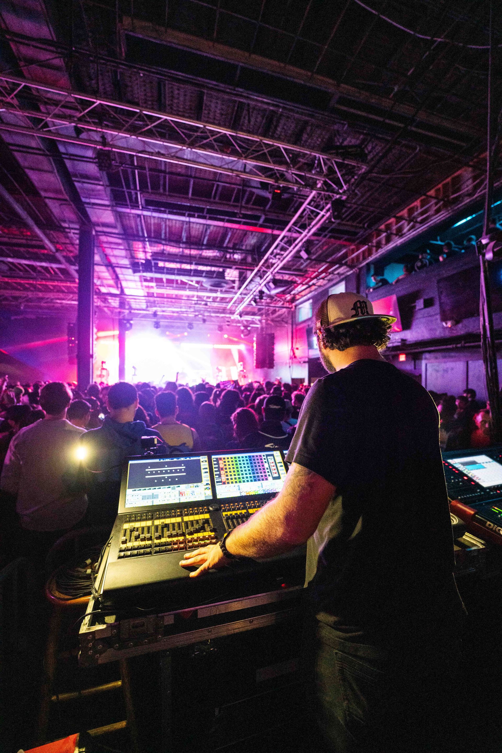 A dj is playing music in front of a crowd at a concert.