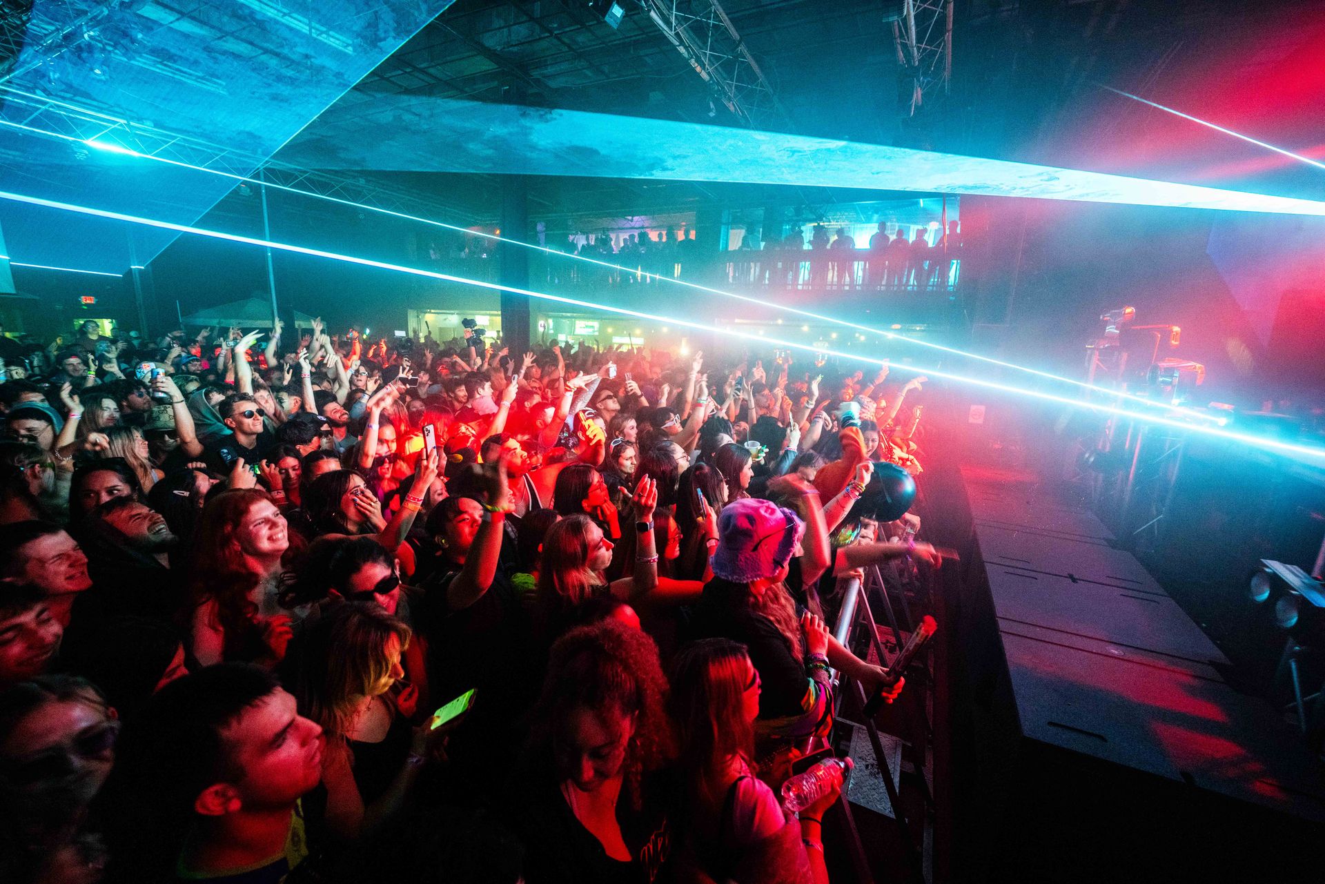 A crowd of people are standing in front of a stage at a concert.