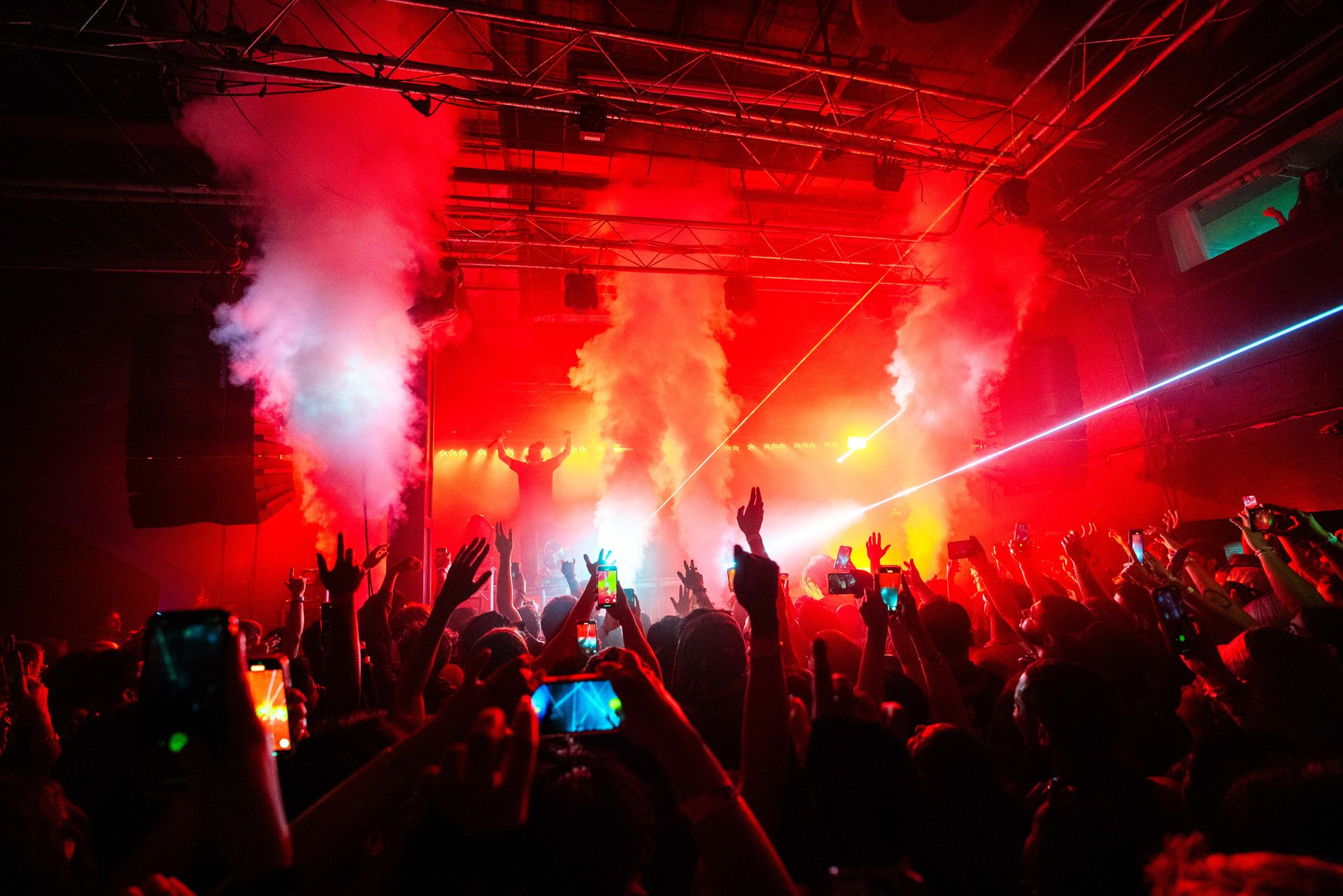 A crowd of people are standing in front of a stage at a concert.