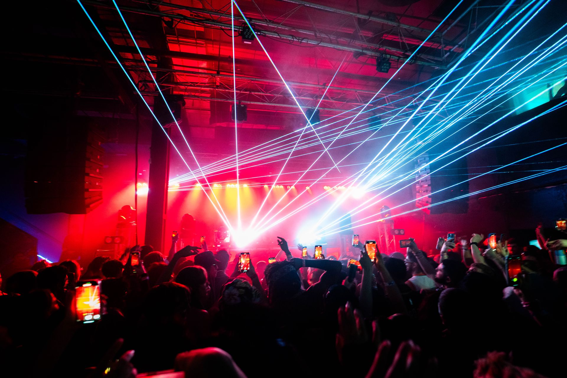 A crowd of people are standing in front of a stage at a concert.