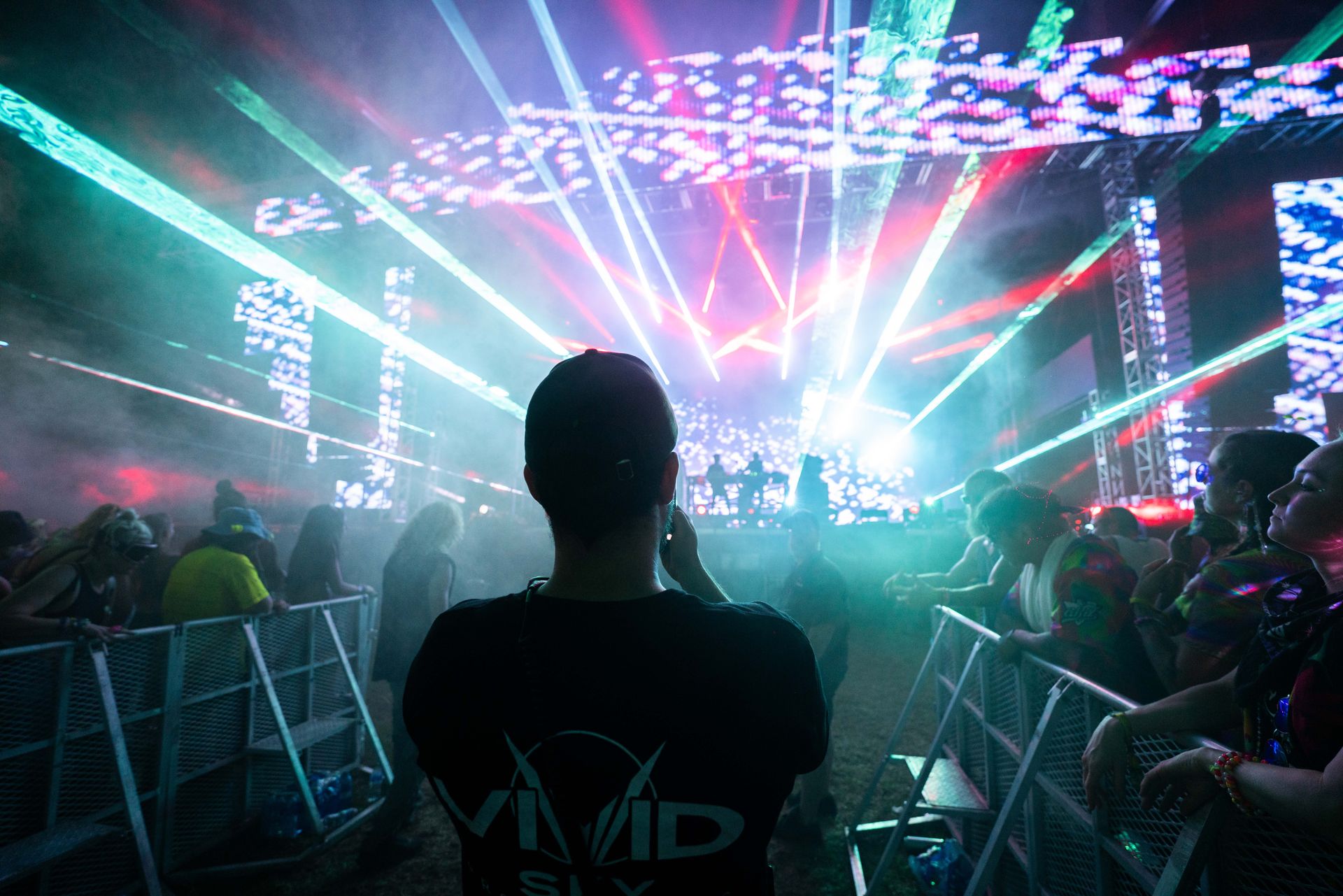 A man in a vivid shirt is watching a concert