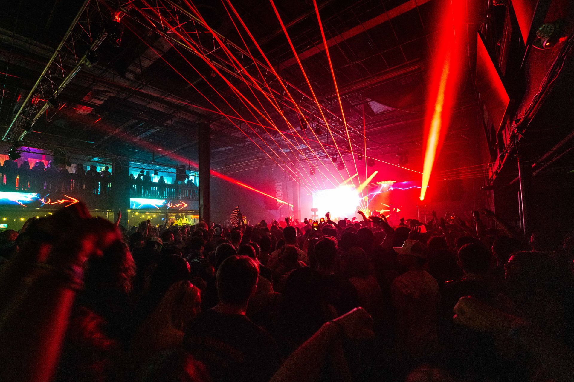 A crowd of people are standing in front of a stage at a concert.