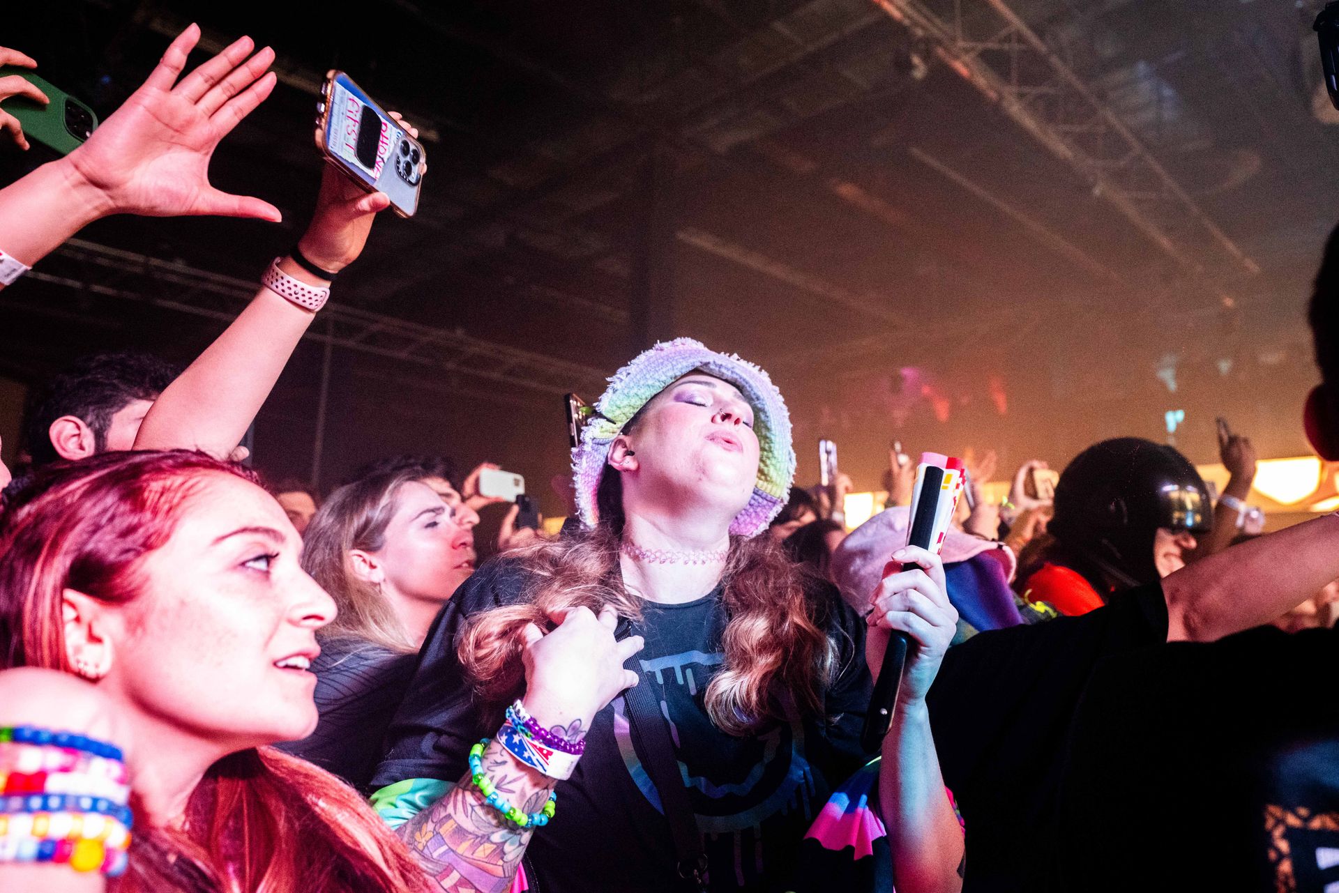 A crowd of people at a concert taking pictures with their phones