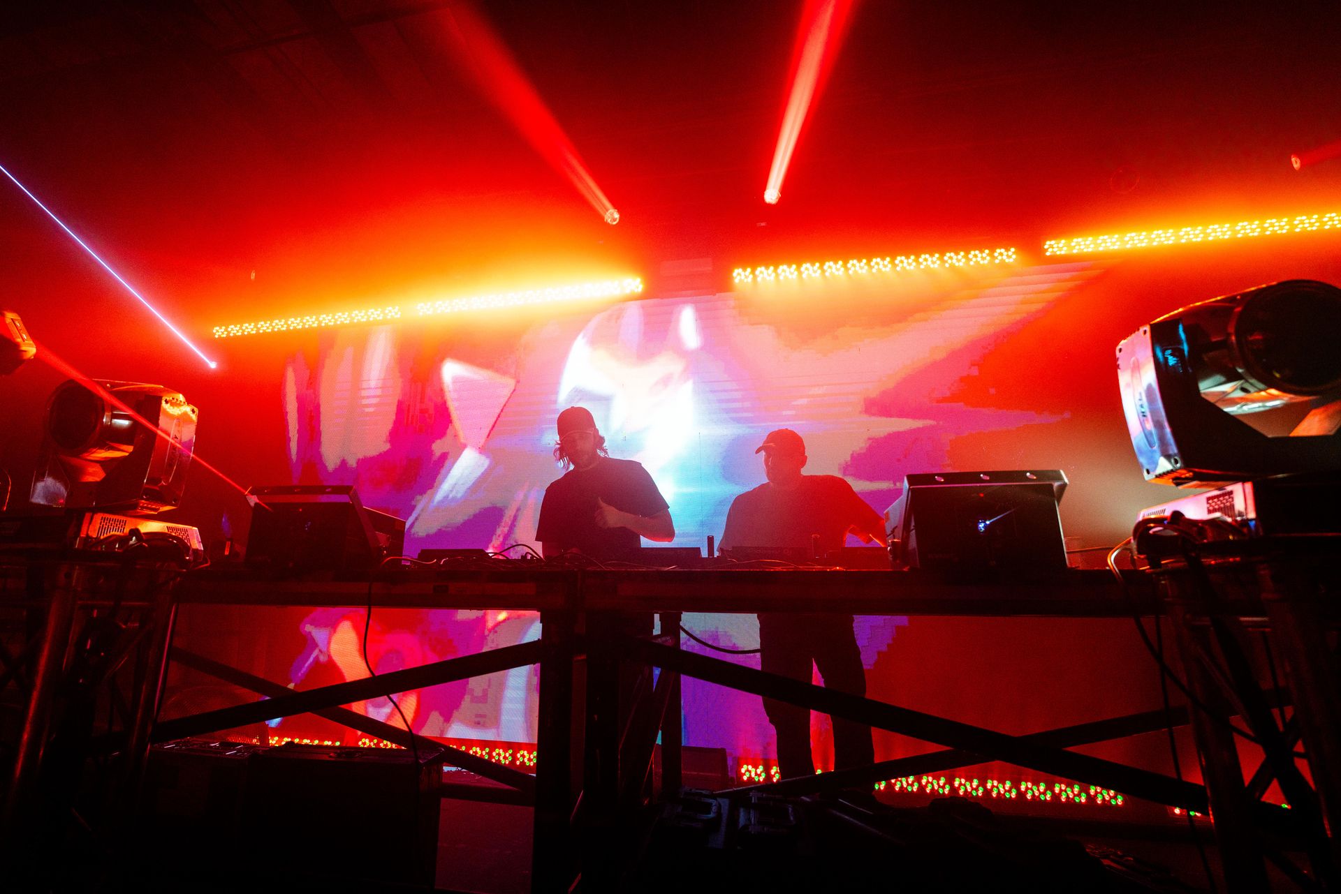 A group of people are playing instruments on a stage in a dark room.