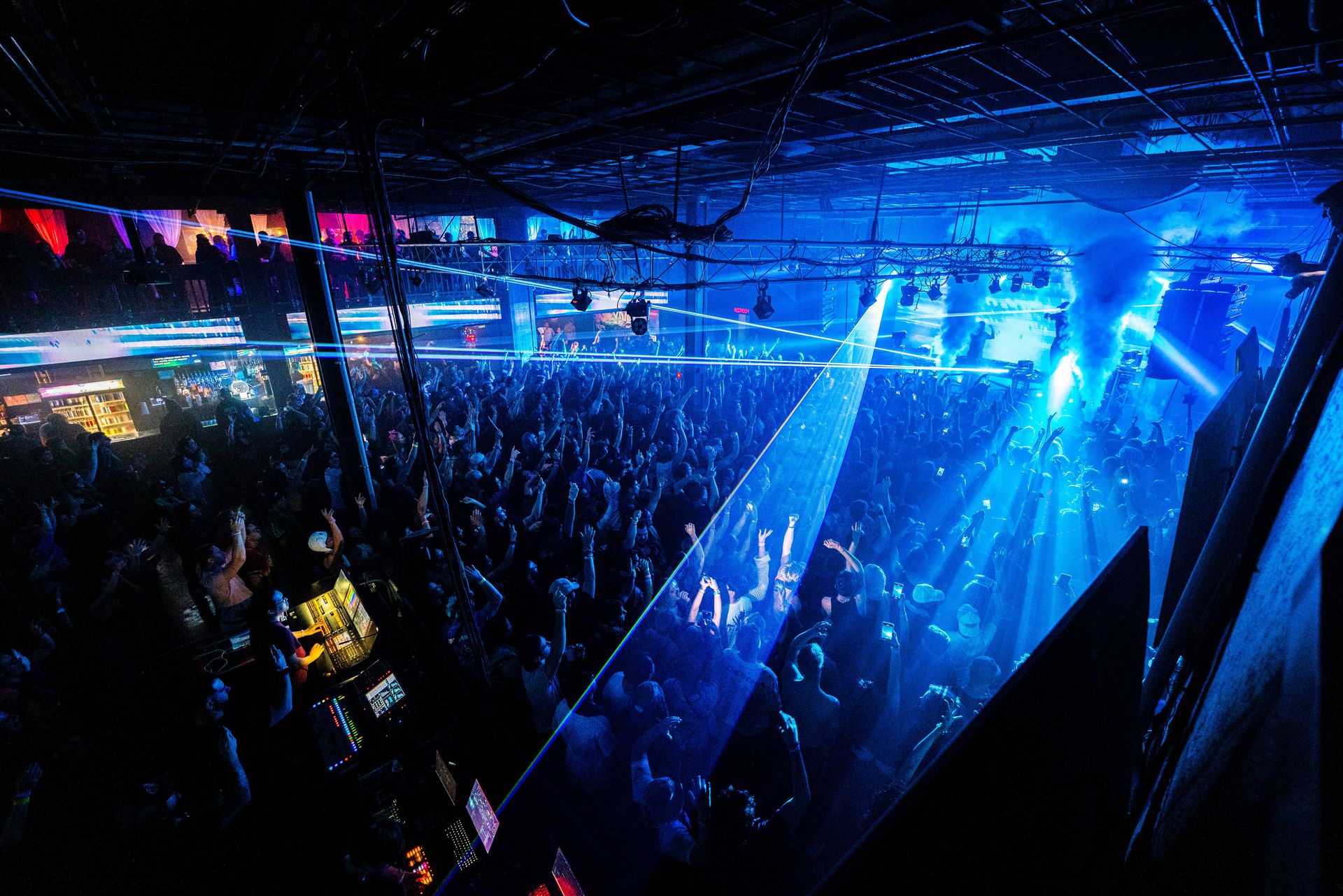 A large crowd of people are dancing in a nightclub.