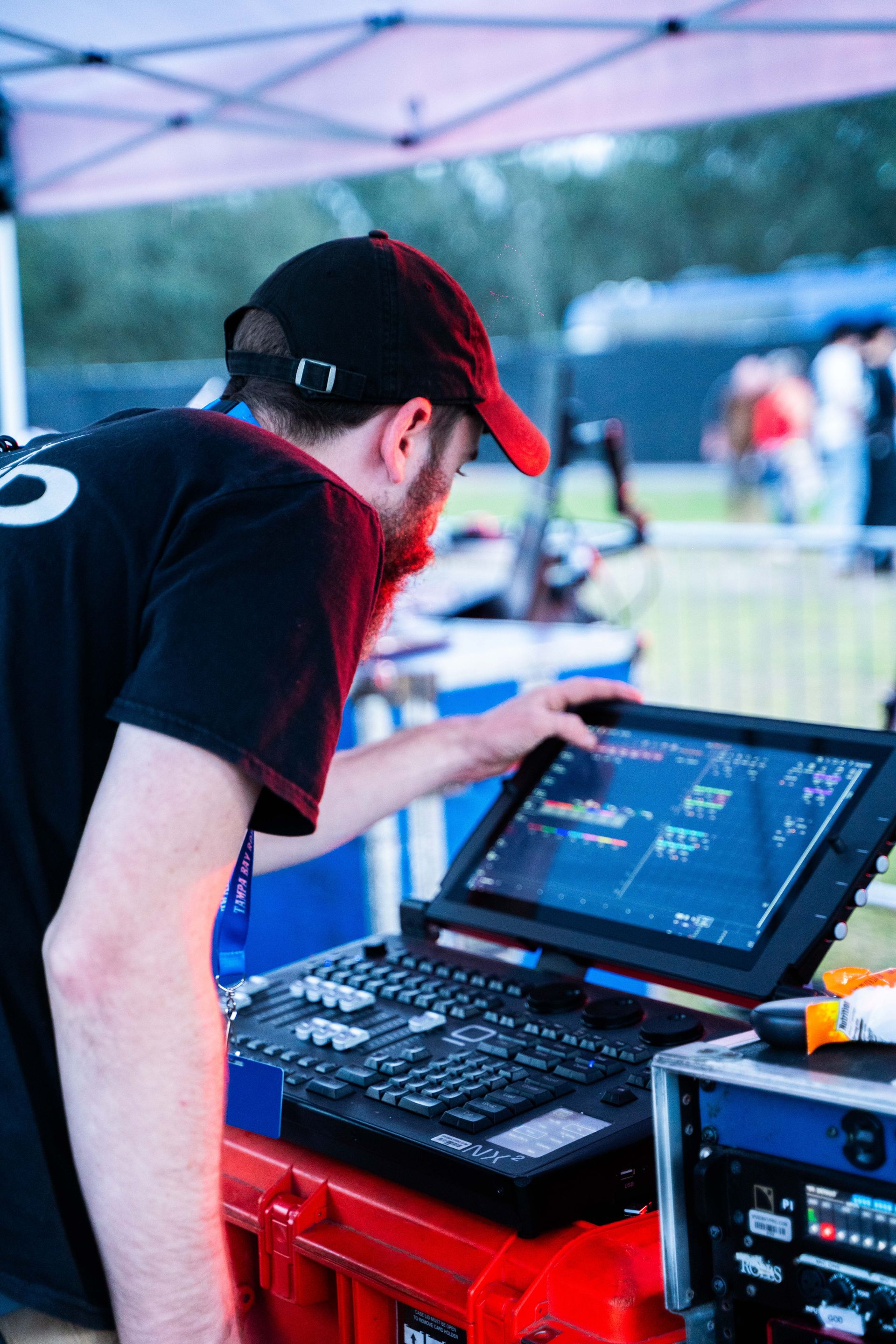 A man in a red hat is looking at a computer screen.