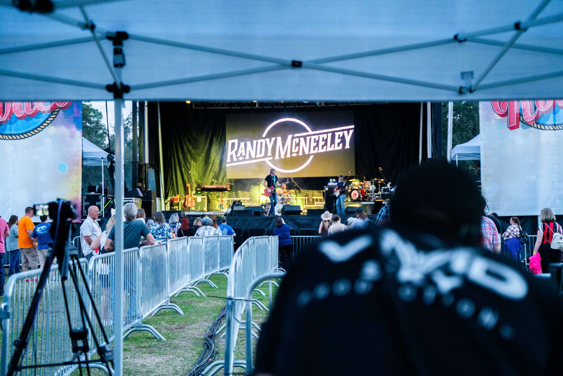A man is standing in front of a stage at a concert.