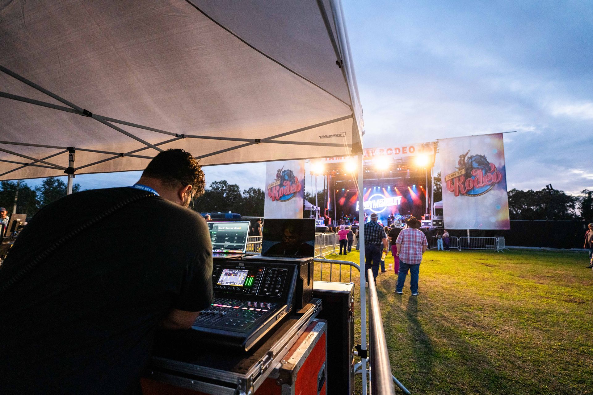 A man is standing in front of a stage at a concert.