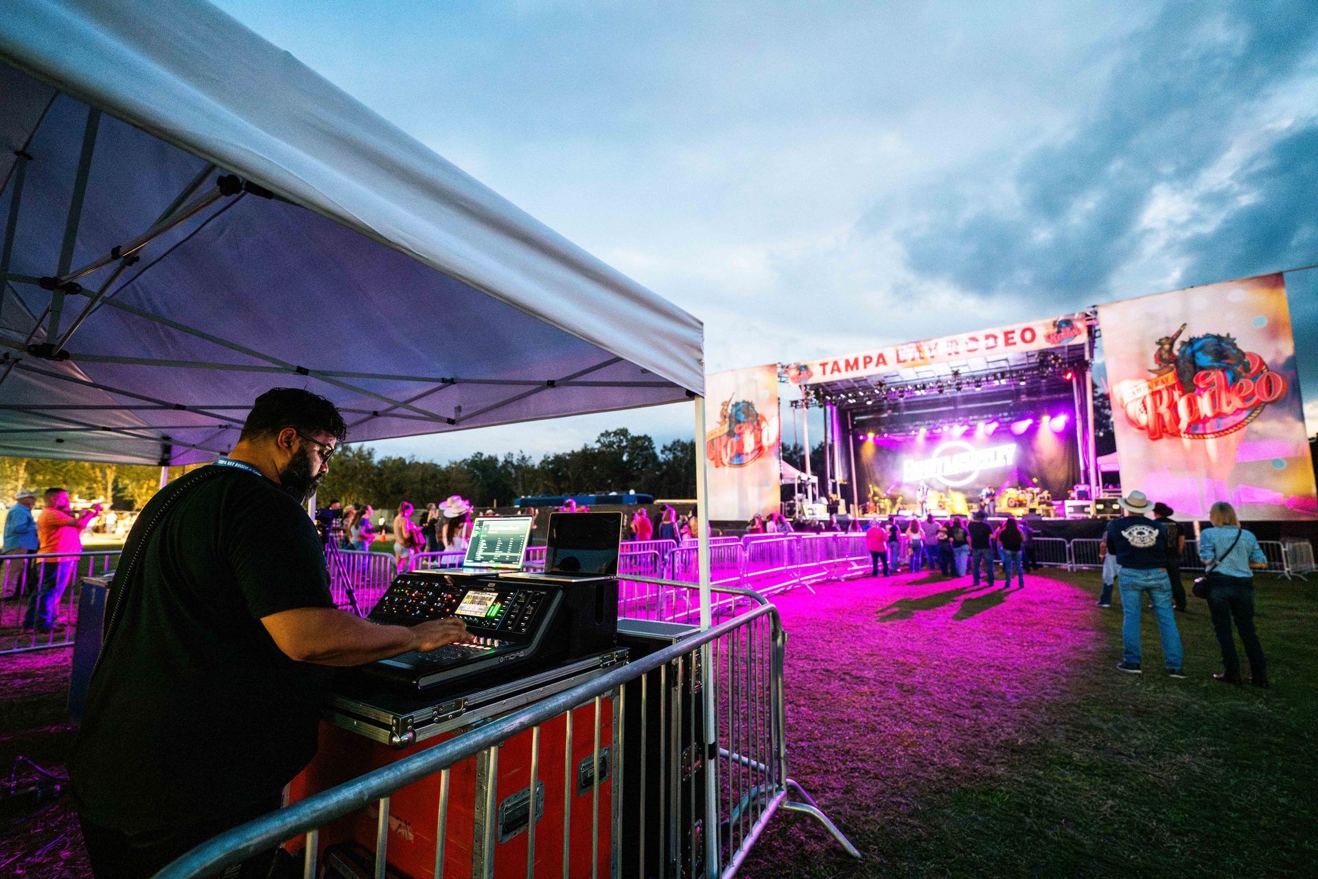 A man is standing in front of a stage at a concert.
