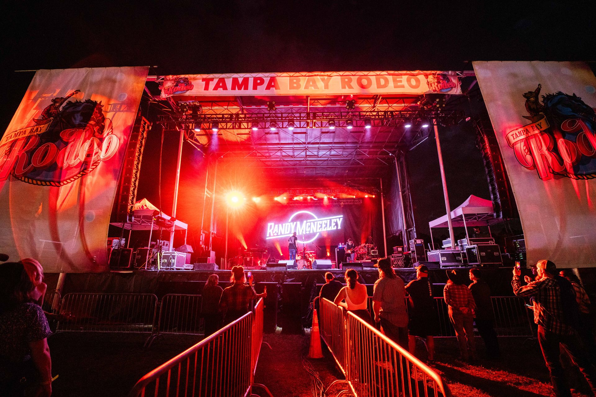 A group of people are standing in front of a stage at a concert.