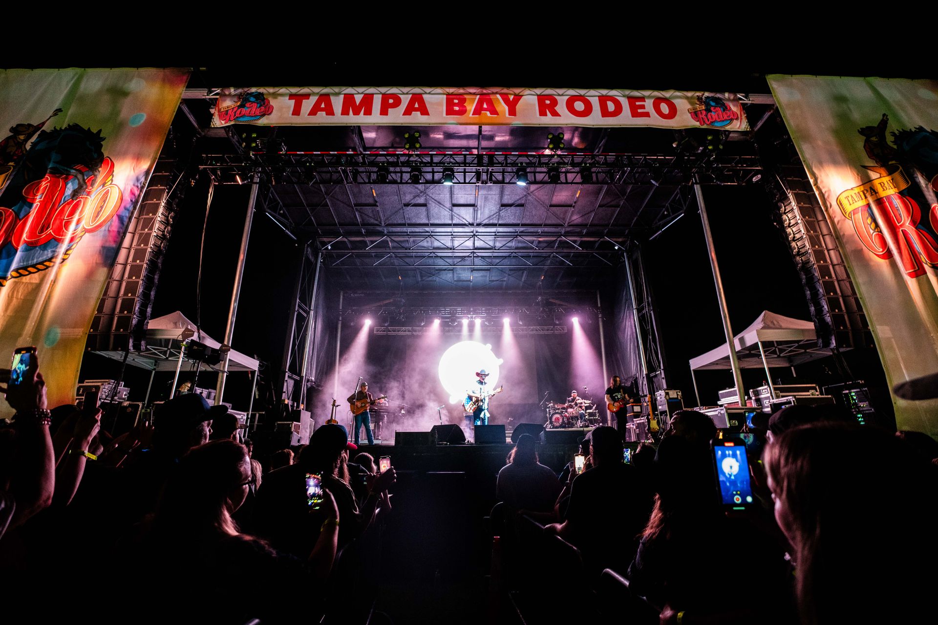 A crowd of people are watching a concert at tampa bay rodeo.