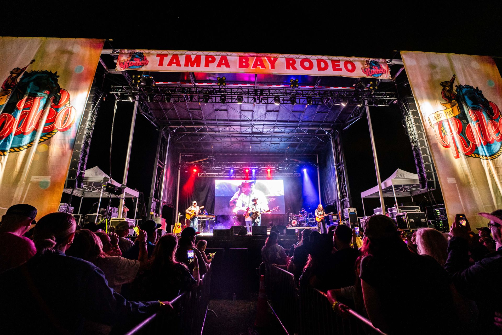 A crowd of people are watching a concert at tampa bay rodeo.