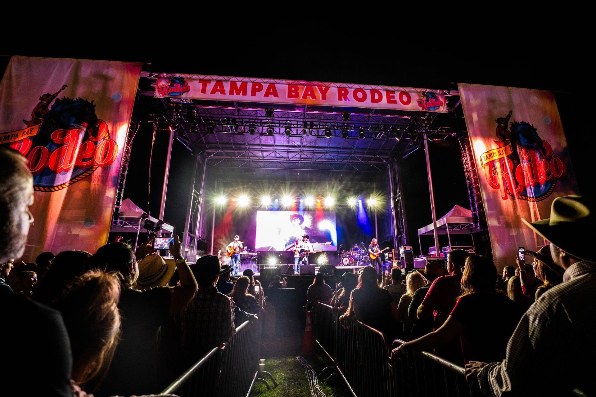 A crowd of people are watching a concert at tampa bay rodeo.