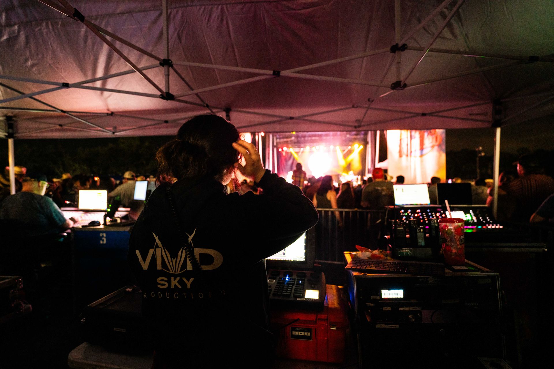 A woman is standing in front of a crowd under a tent.