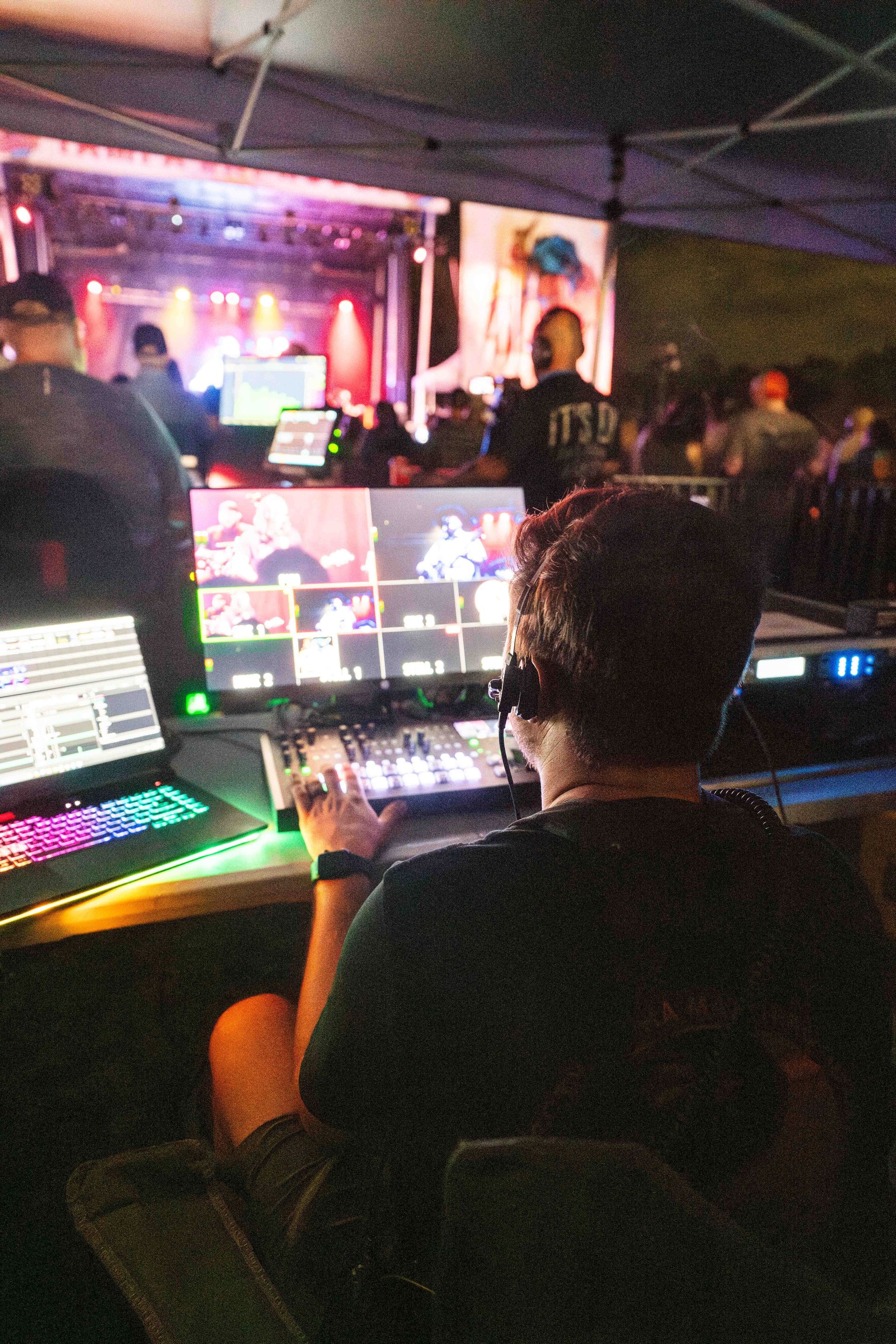 A man wearing headphones is sitting in front of a laptop computer.