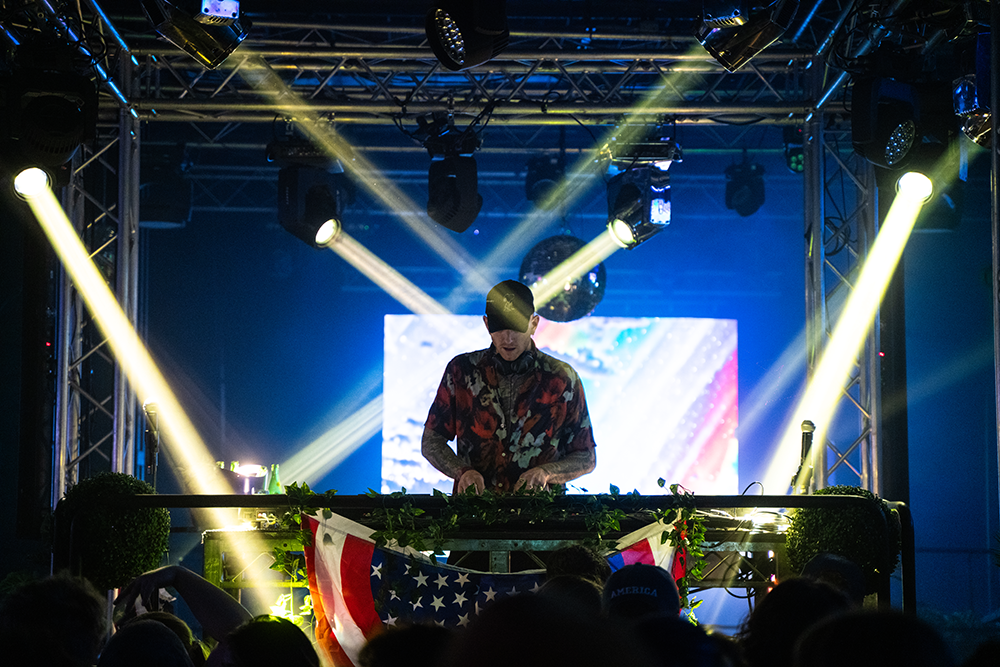 A dj is playing music on a stage in front of a crowd.