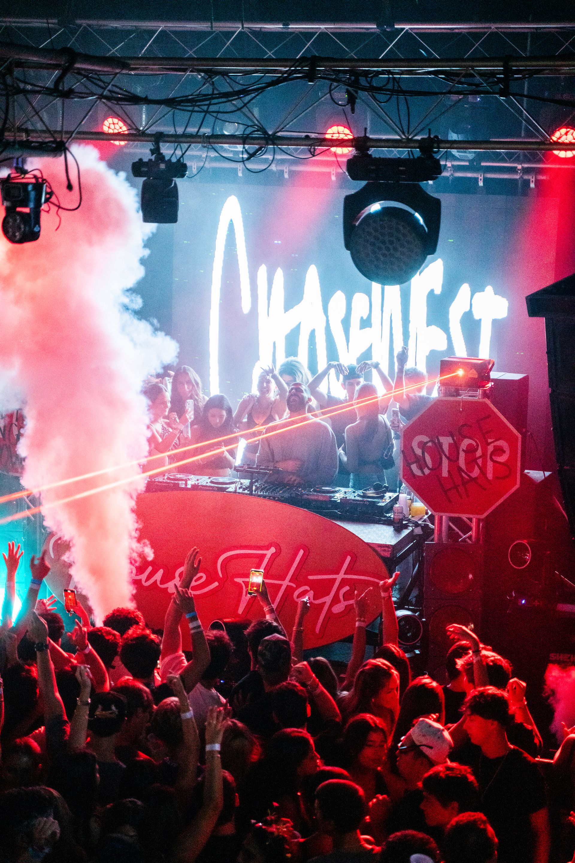 A crowd of people at a concert with a stop sign in the foreground.