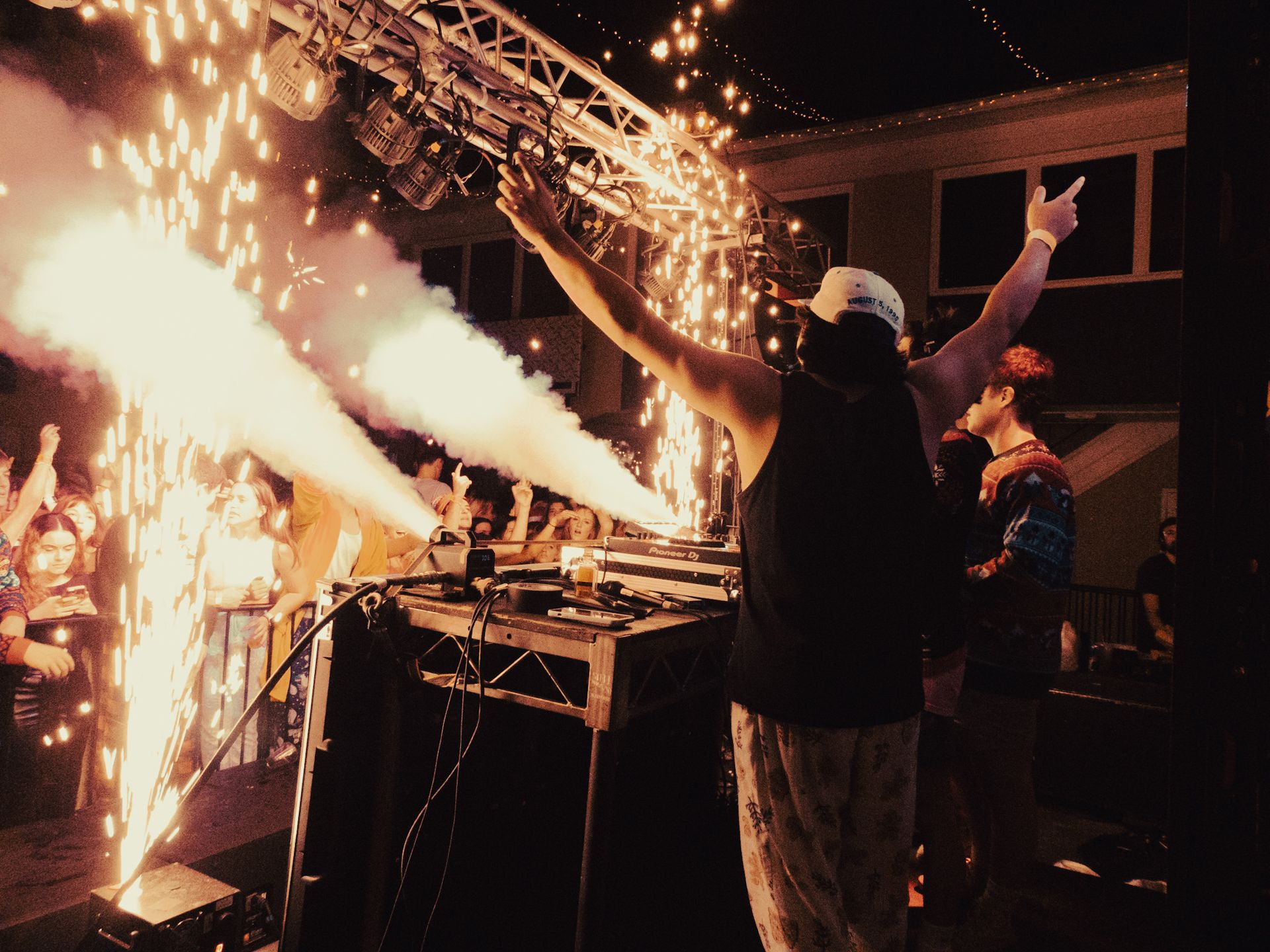 A man is standing on a stage with his arms in the air