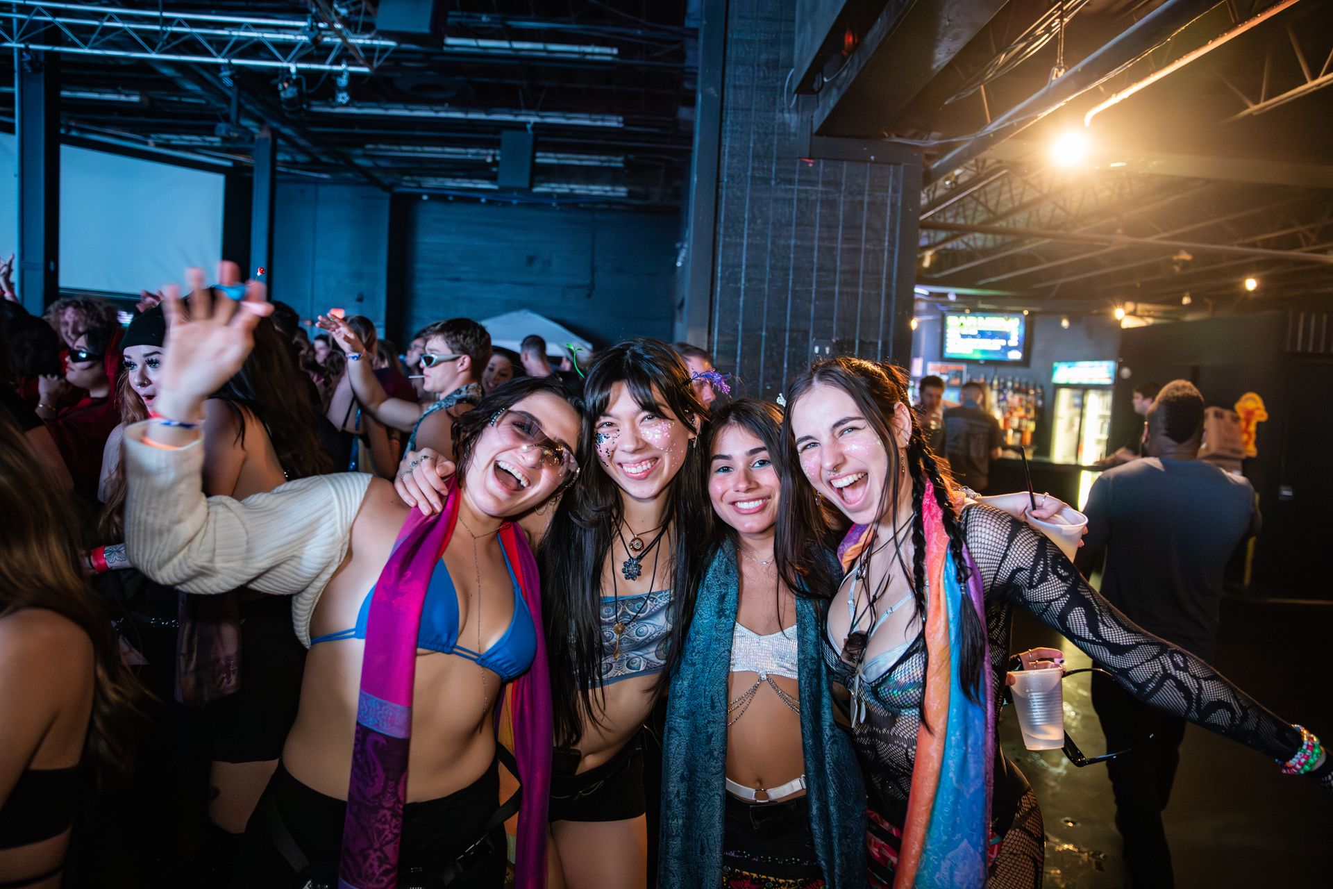 A group of women are posing for a picture in a club.