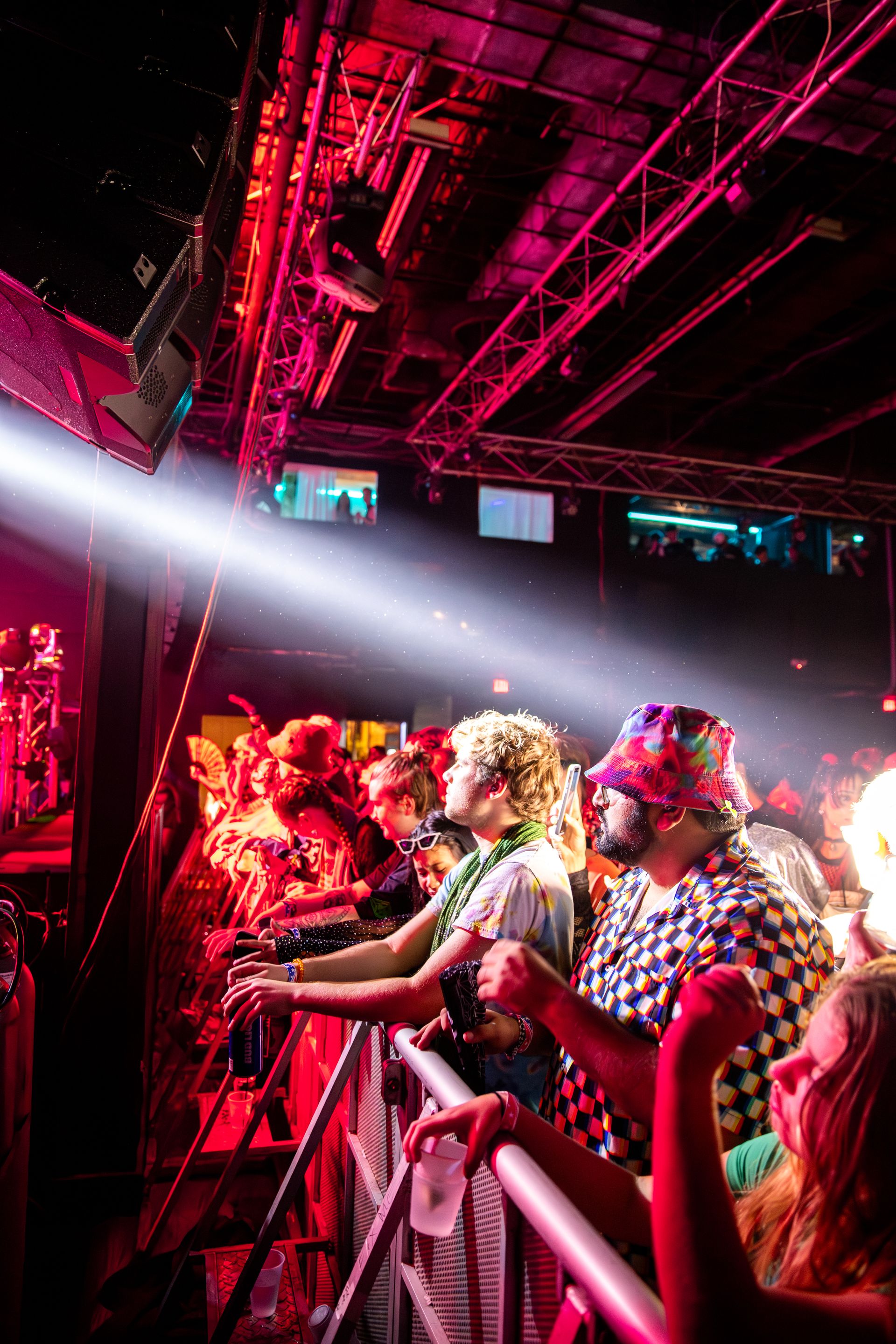 A crowd of people are standing in front of a stage at a concert.