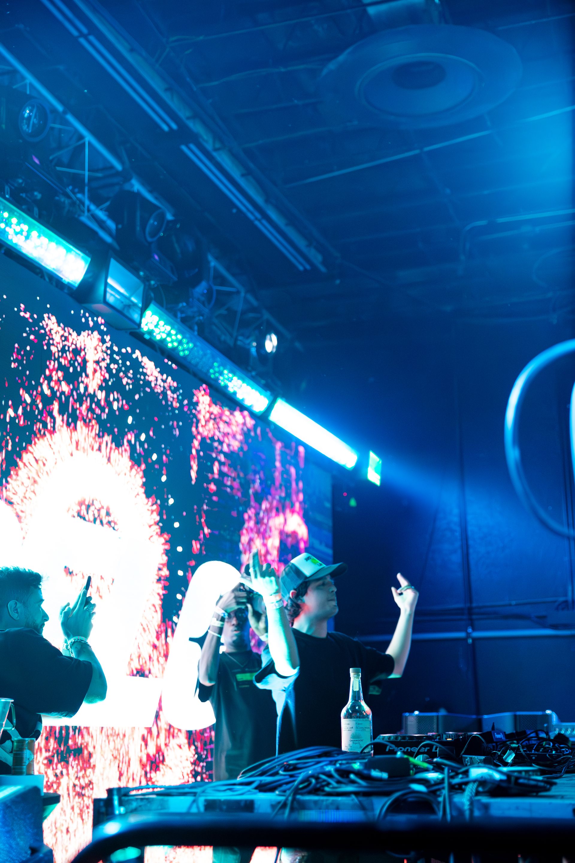 A group of people are standing in front of a large screen in a dark room.