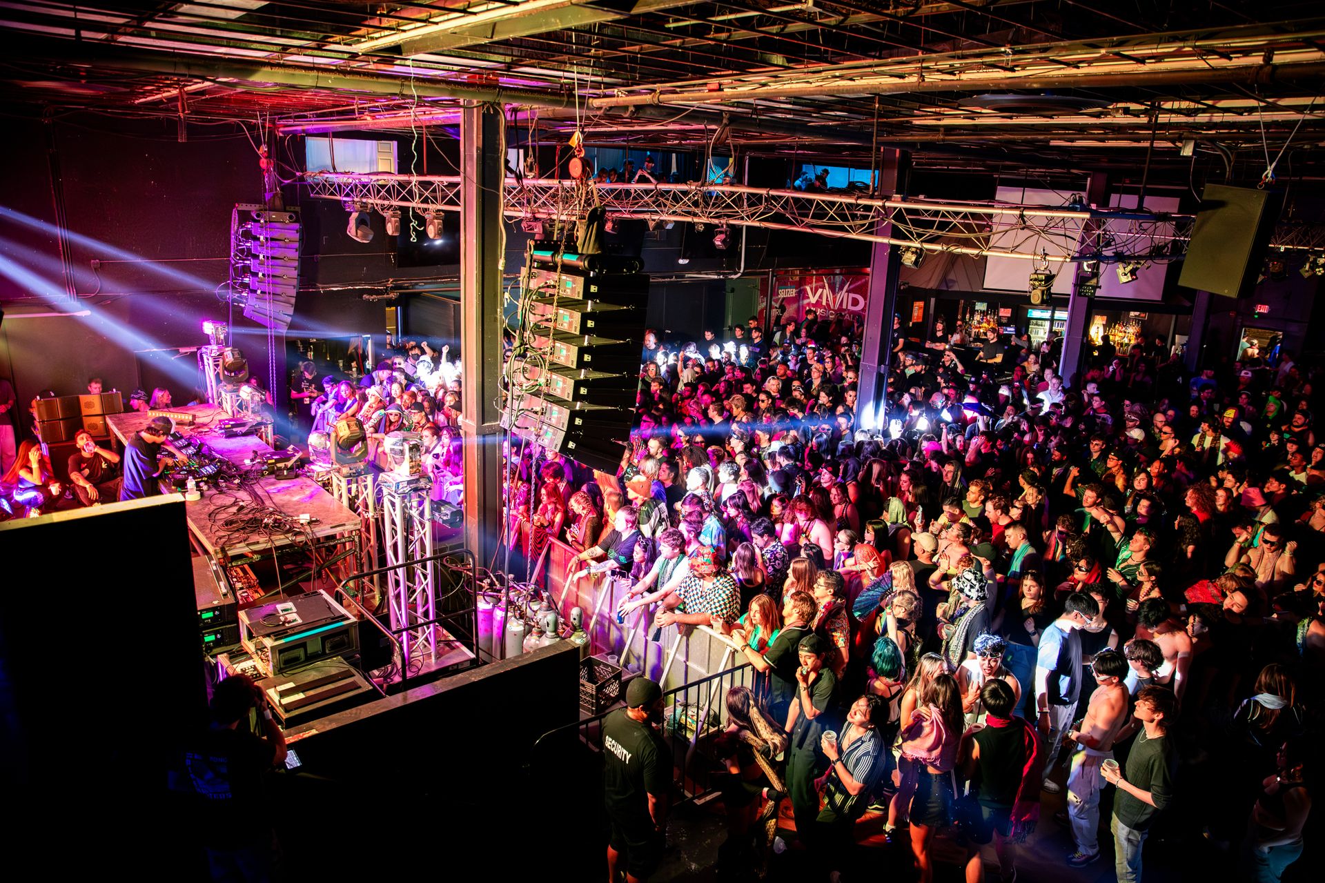 A large crowd of people are standing in front of a stage at a concert.