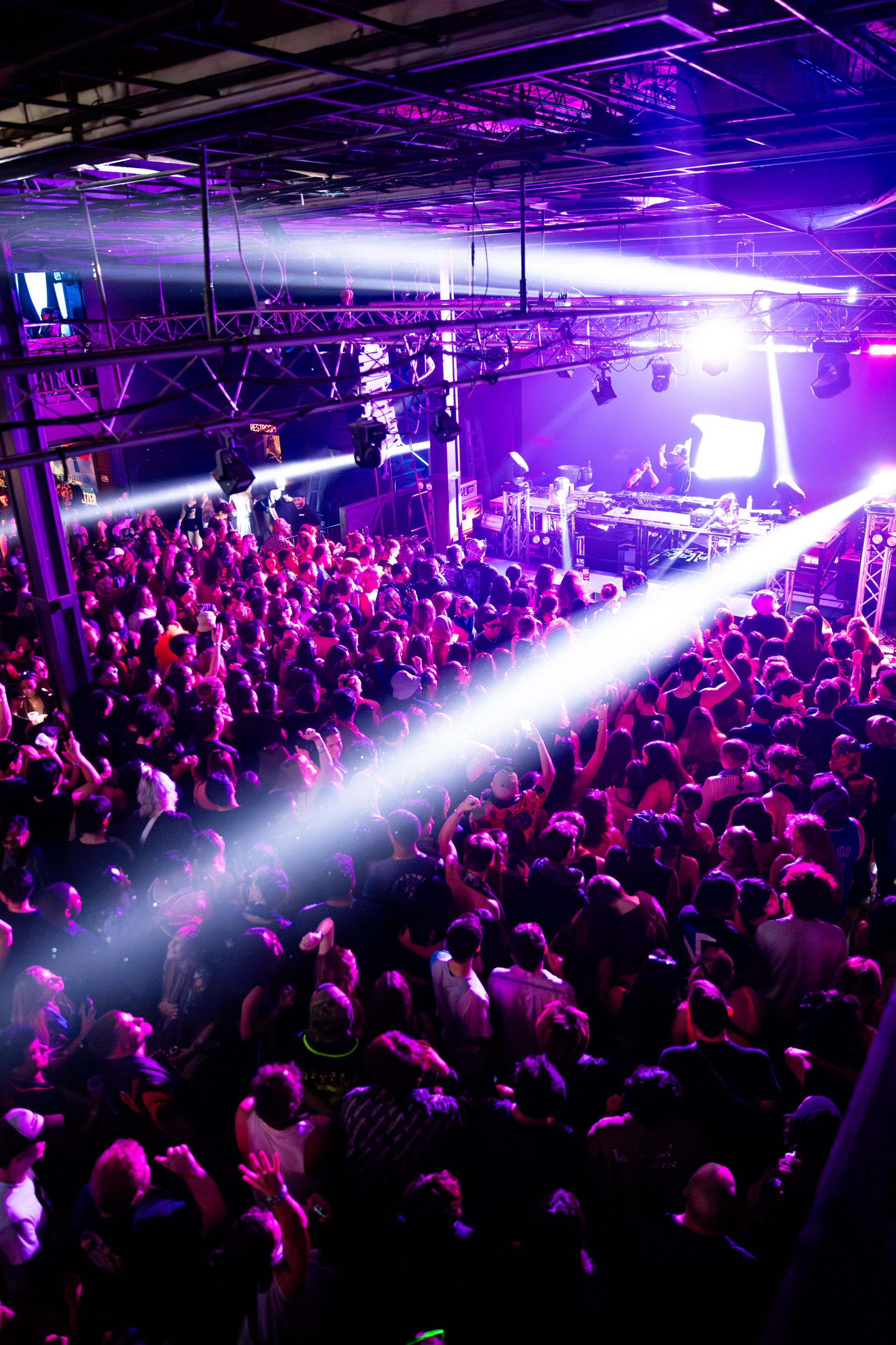 A crowd of people are standing in front of a stage at a concert.