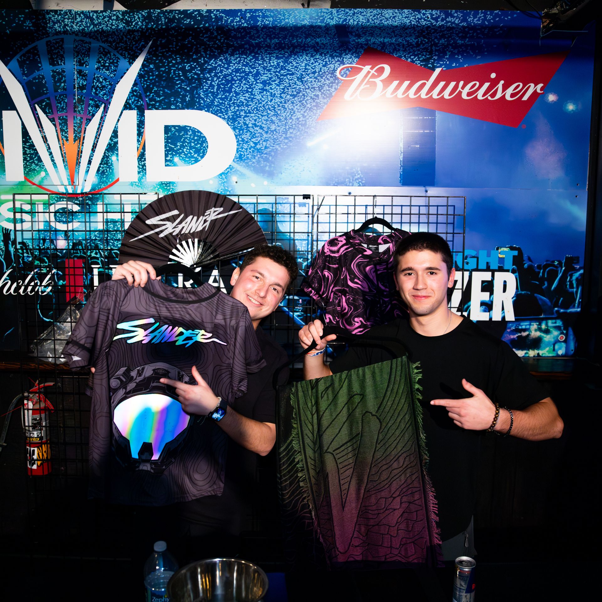 Two men standing in front of a budweiser sign
