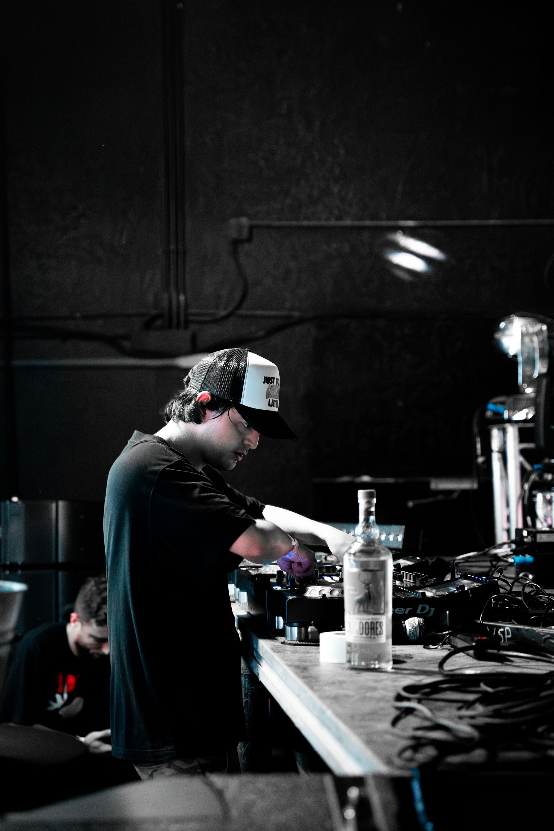 A man wearing a hat is standing in a dark room