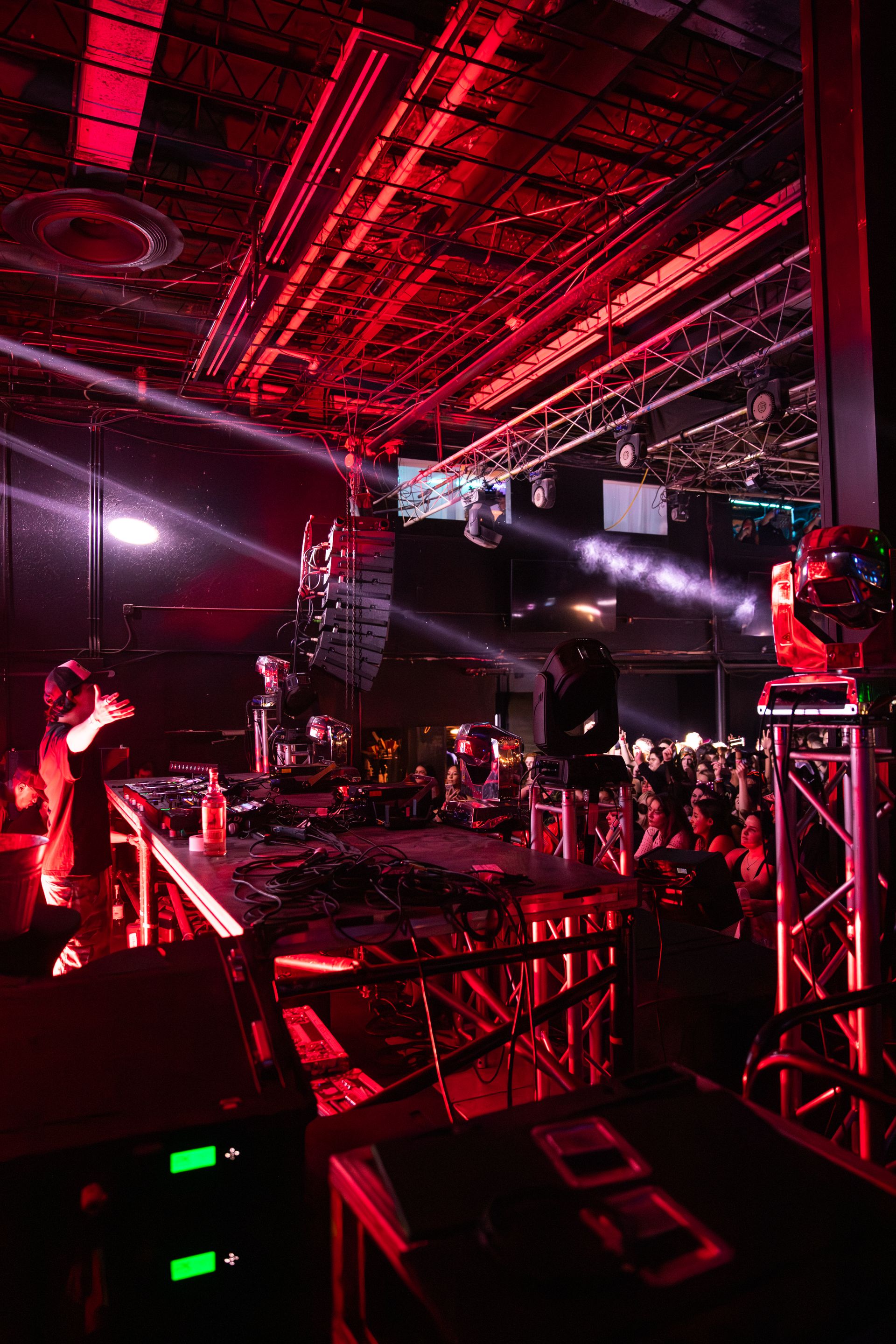 A group of people are standing in a dark room with red lights.