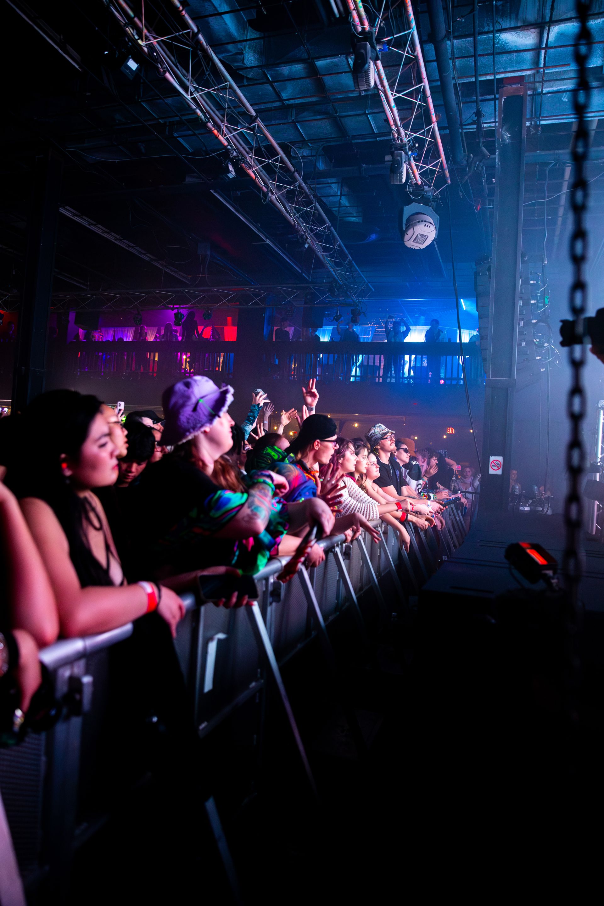 A crowd of people are watching a concert in a dark room.