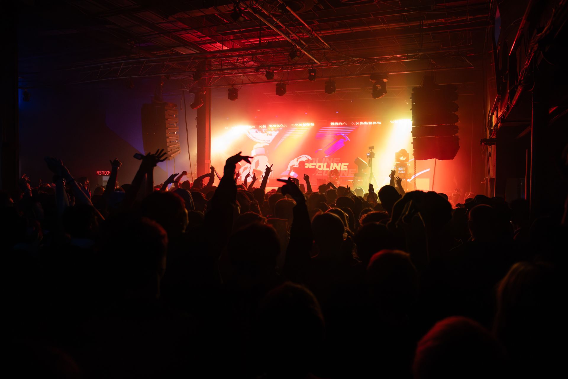 A crowd of people are standing in front of a stage at a concert.