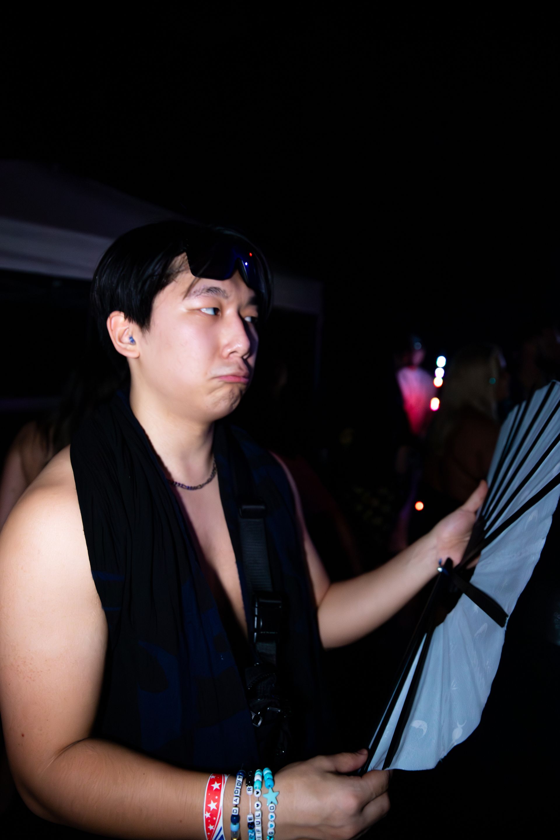 A man is holding an umbrella in a dark room