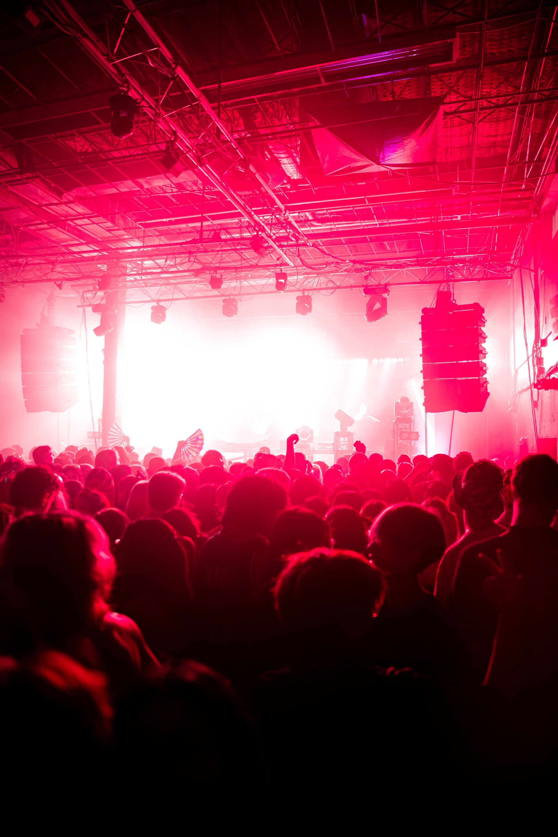 A crowd of people are standing in front of a stage at a concert.