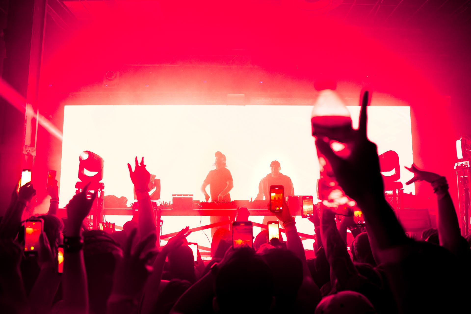 A crowd of people are standing in front of a stage at a concert.