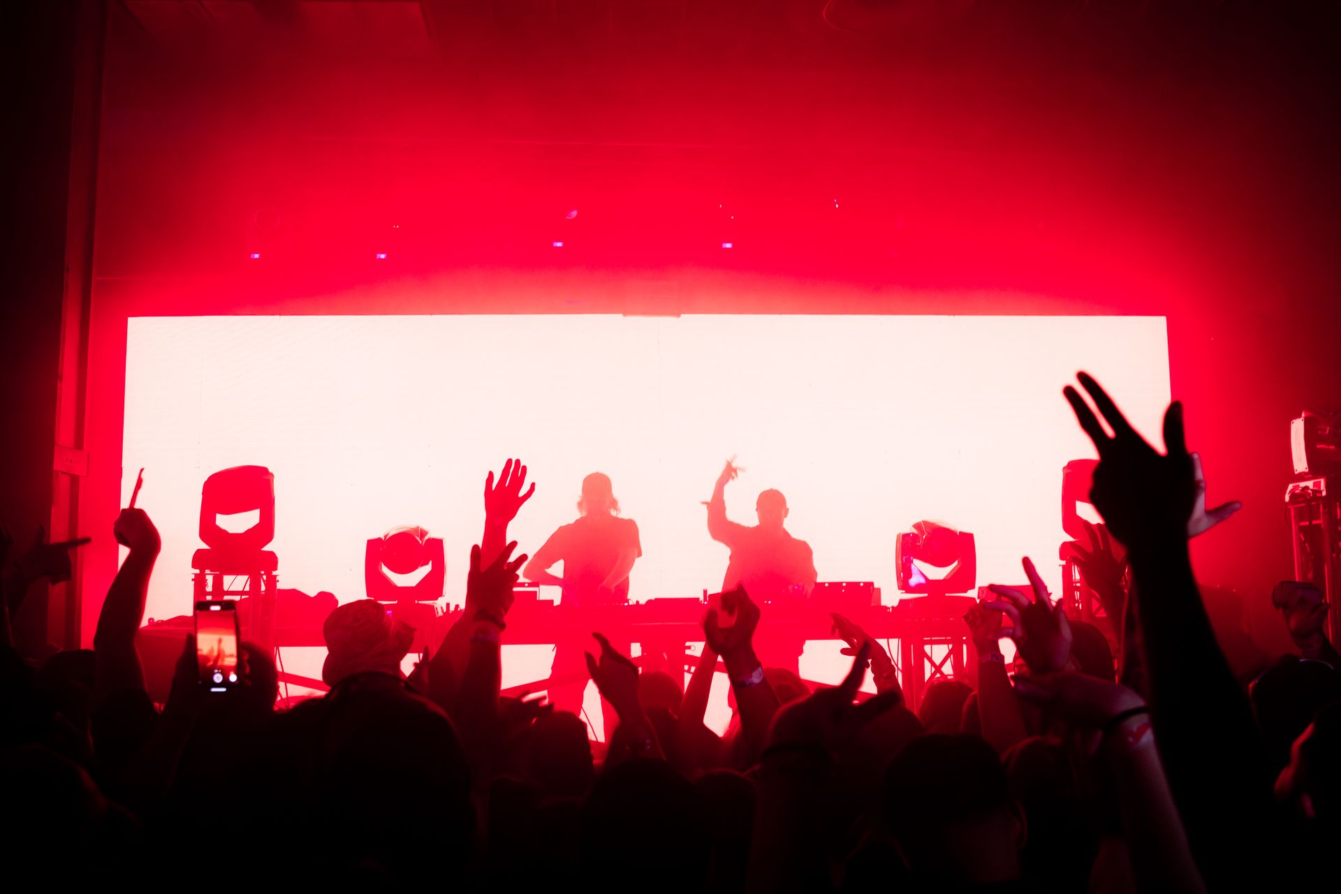 A crowd of people are standing in front of a stage at a concert.
