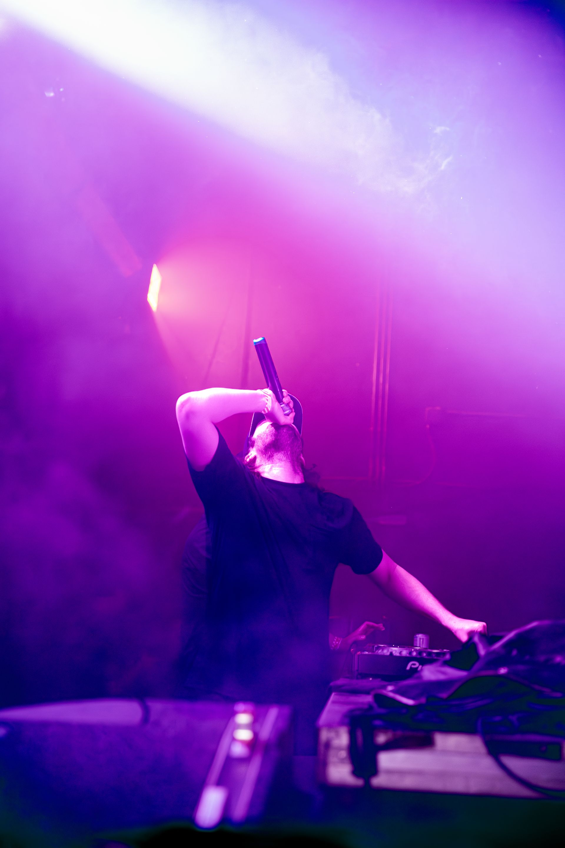 A man is holding a microphone in front of a purple background.