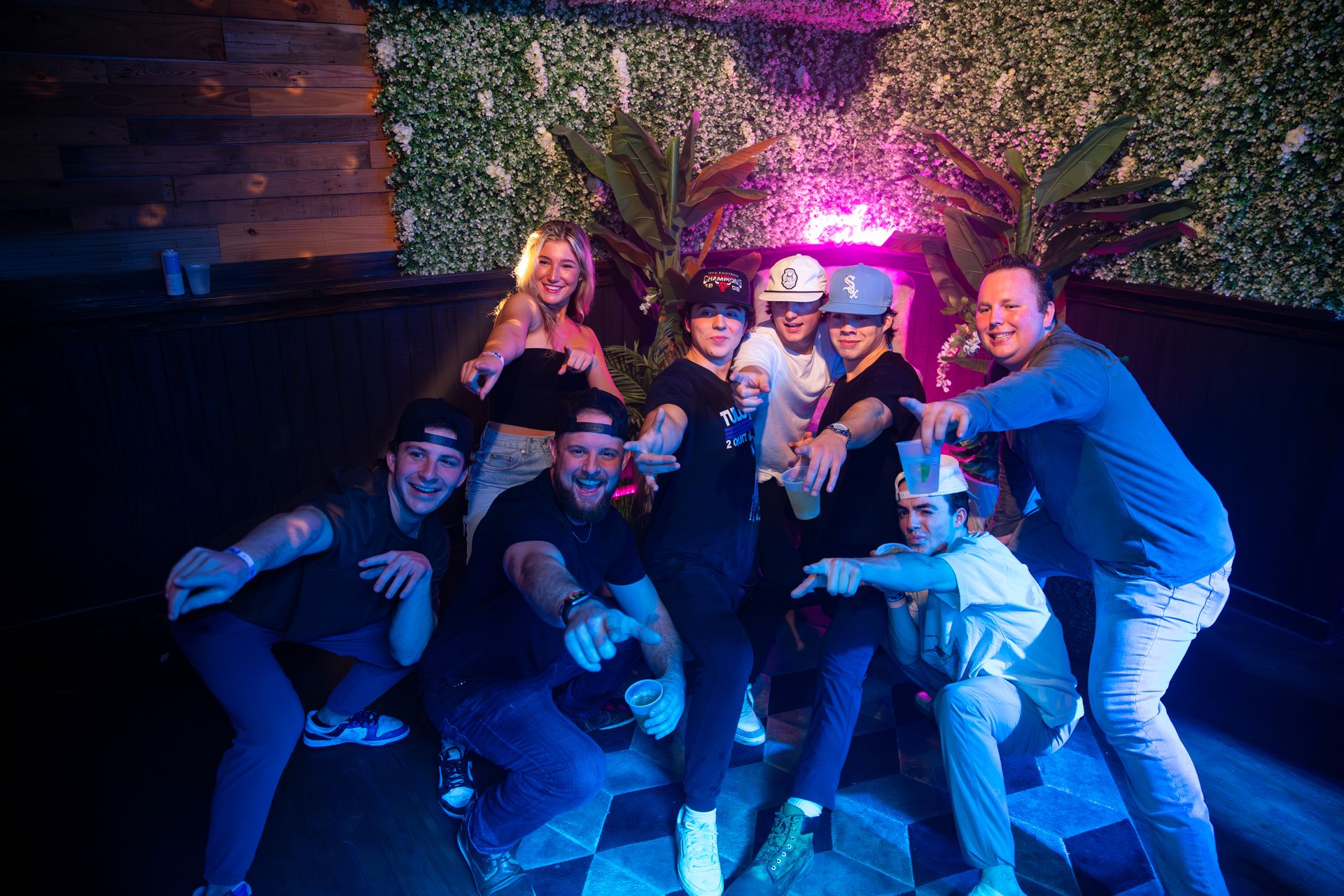 A group of people are posing for a picture in a dark room.