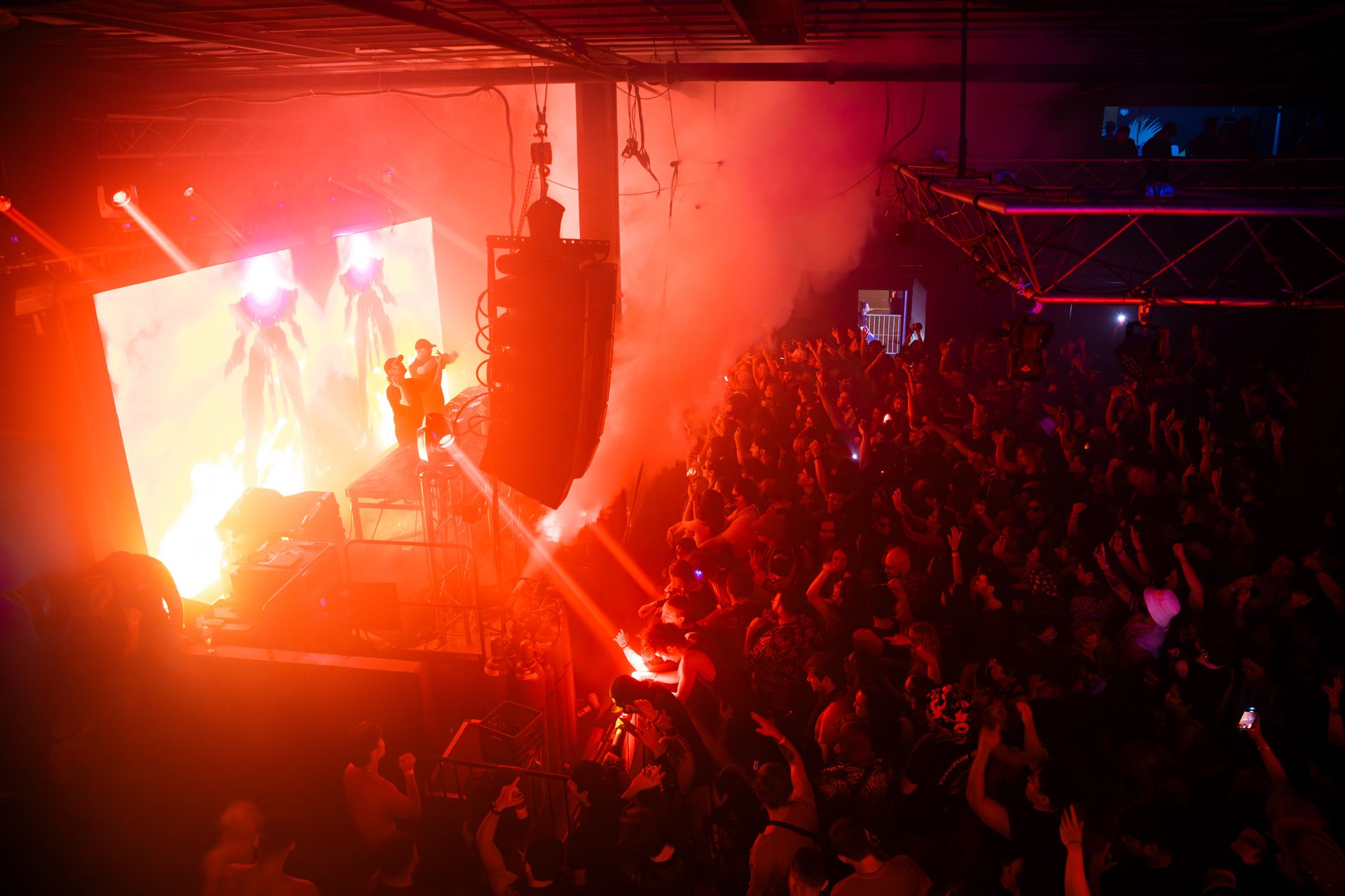 A crowd of people are standing in front of a stage at a concert.