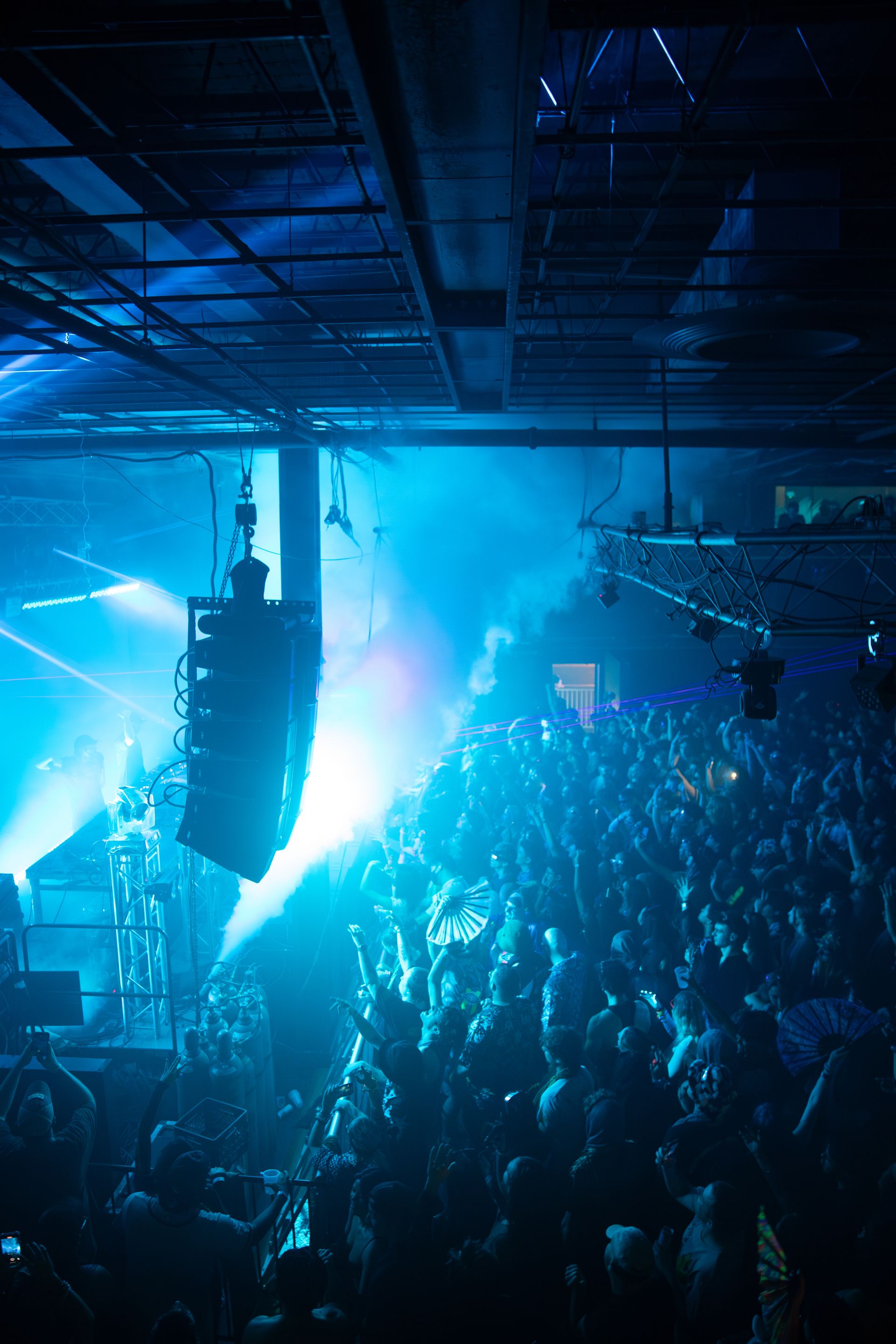 A crowd of people in a dark room with blue lights