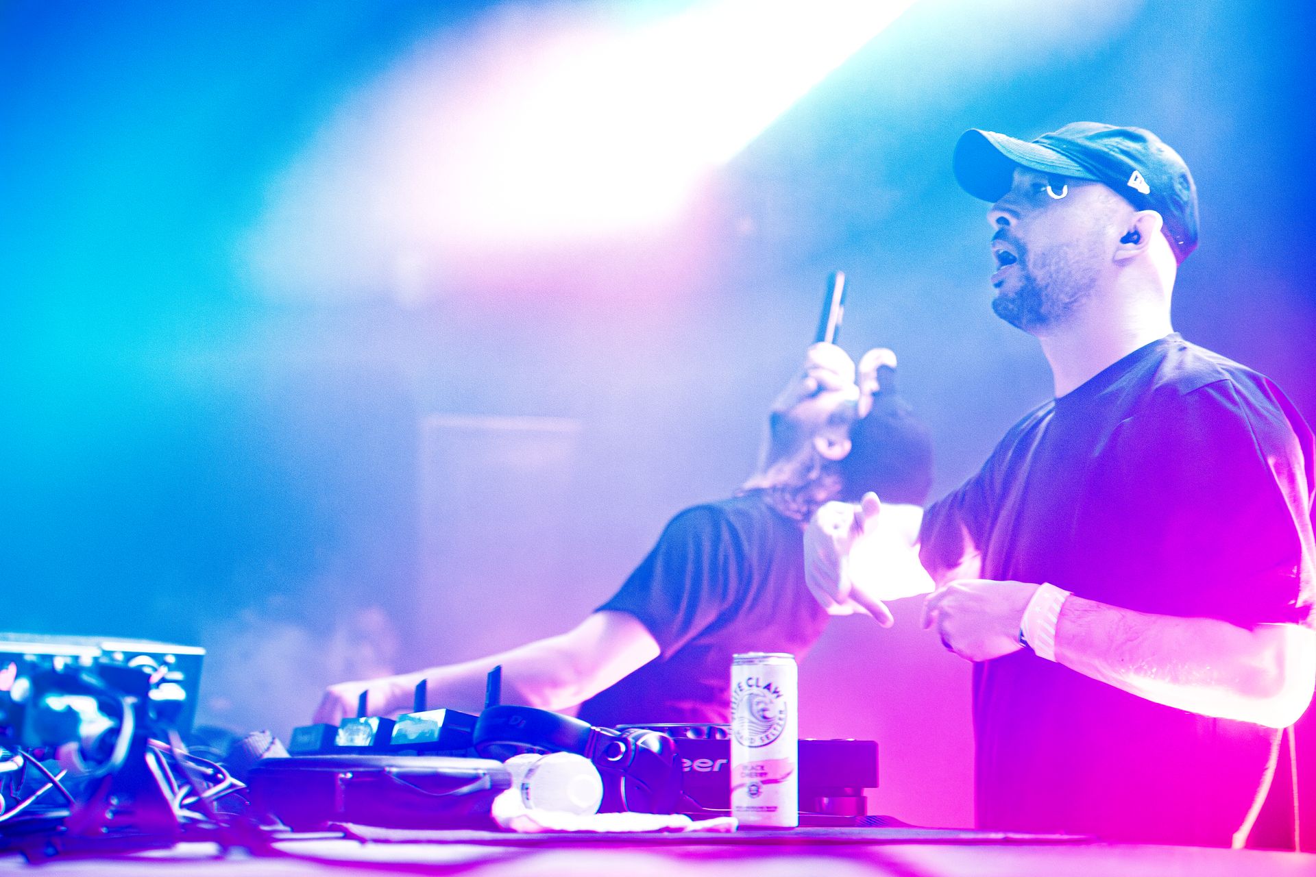 A man is holding a microphone while another man stands behind him.