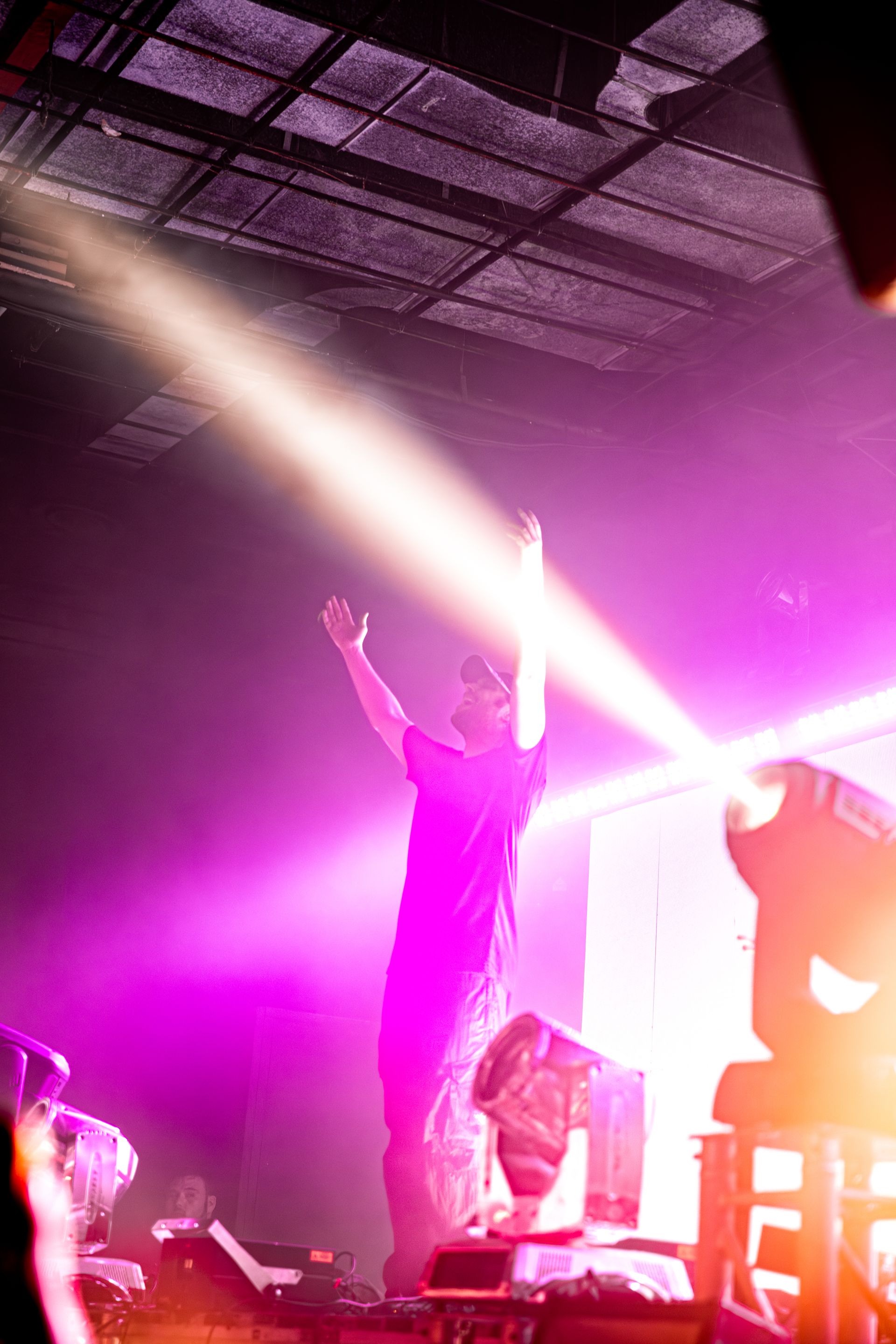A man is standing on a stage with his arms in the air.