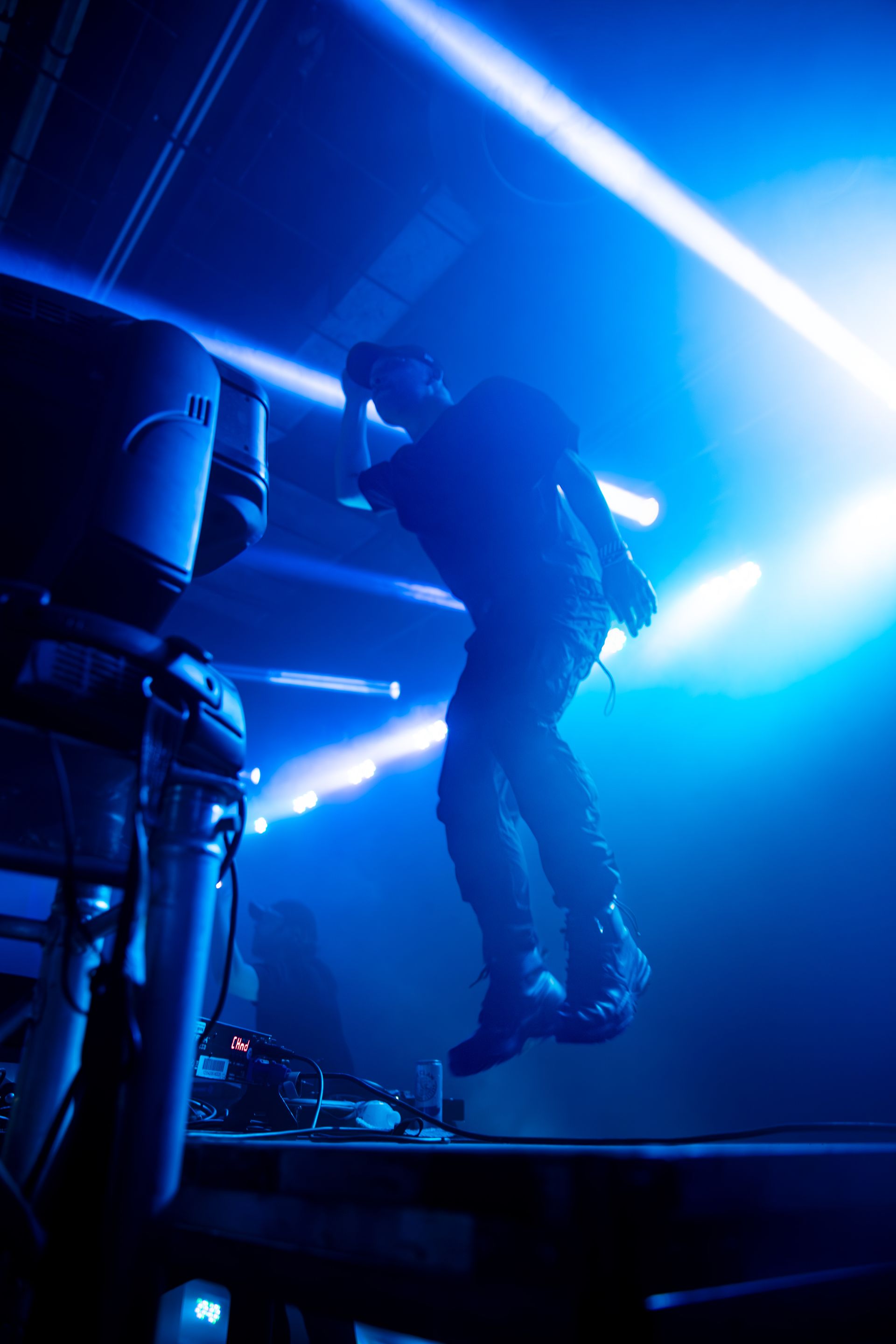 A man is standing on a stage in front of a blue light.