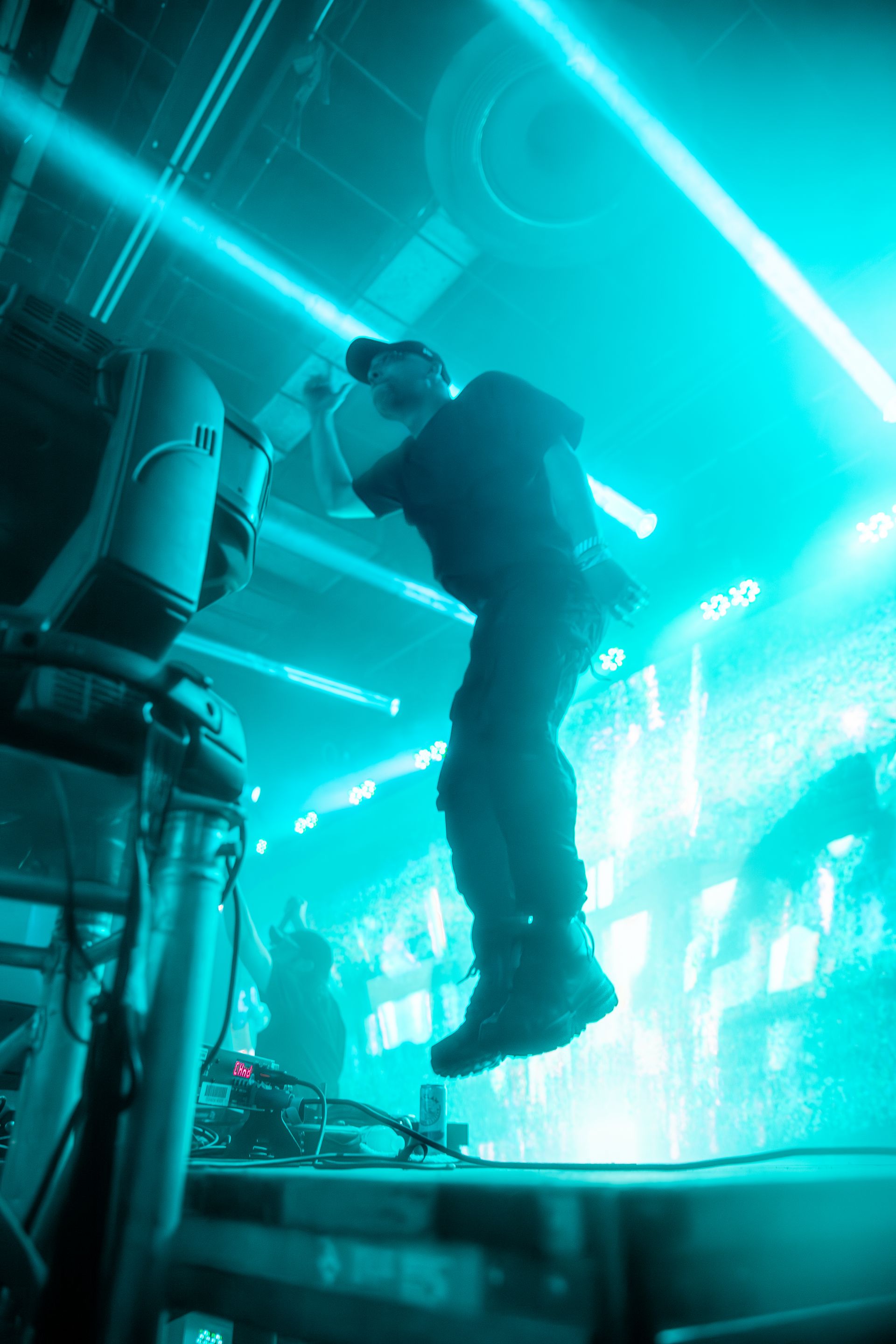 A man is standing on a stage in front of a blue light.