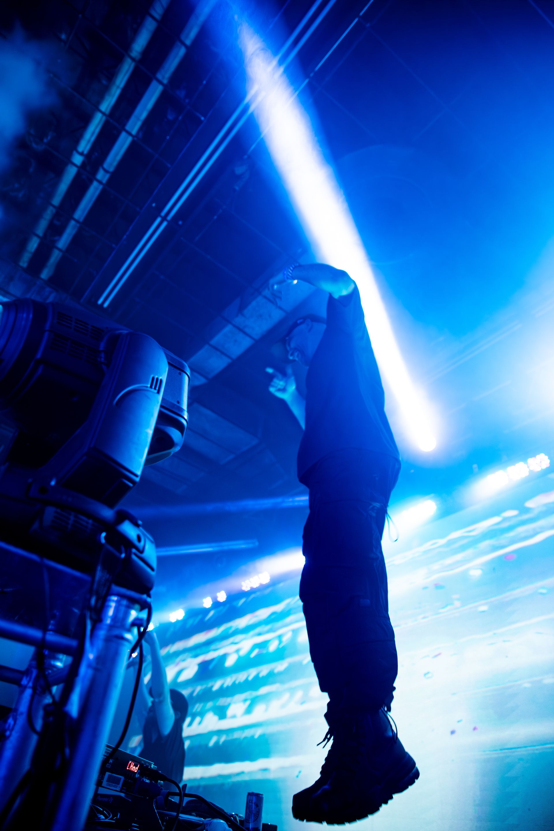 A person standing on a stage with a blue light behind them