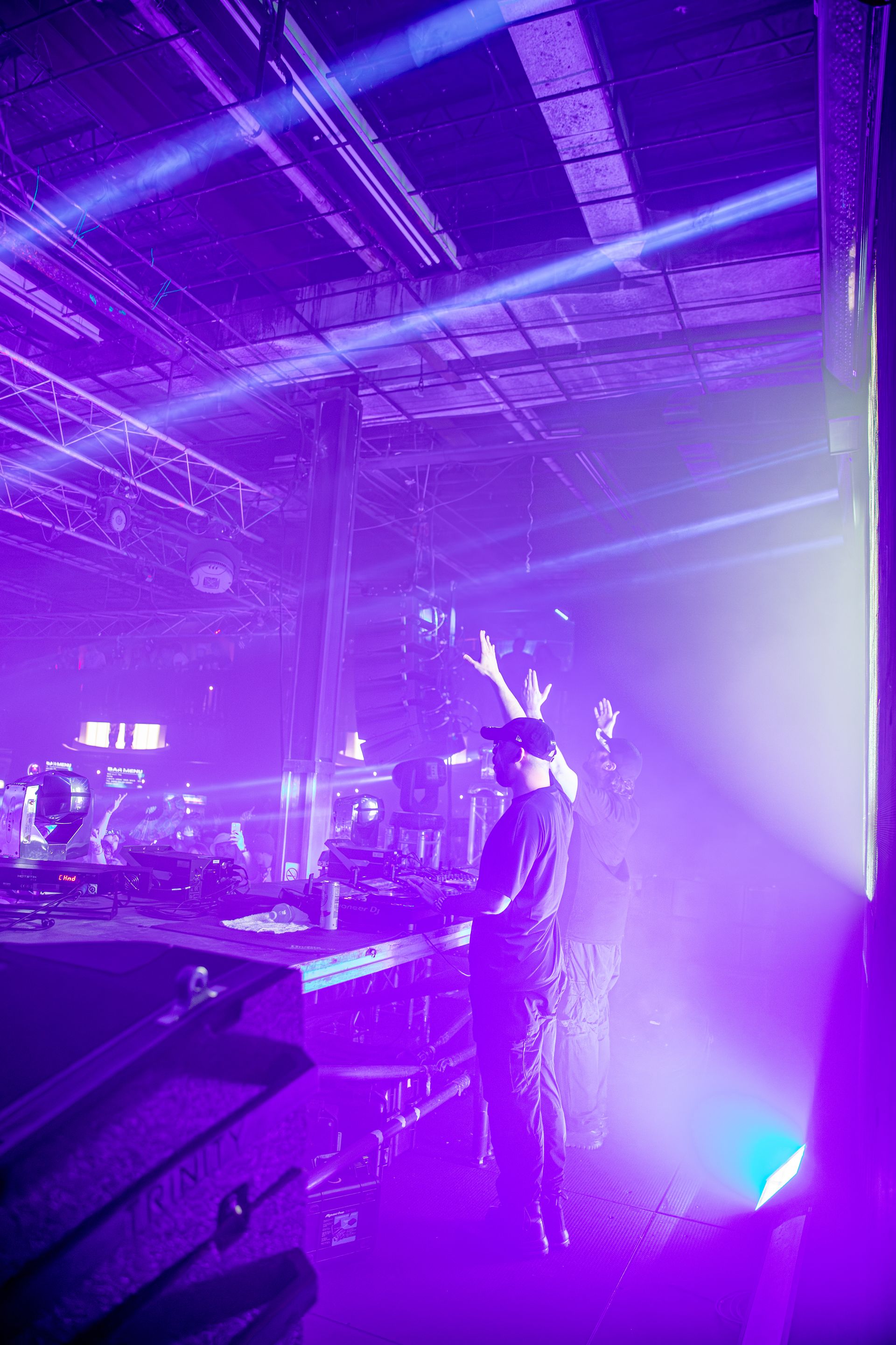 A man is playing a keyboard in a dark room with purple lights.