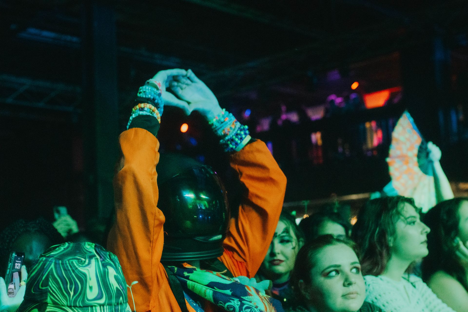 A group of people are sitting in a dark room at a concert.