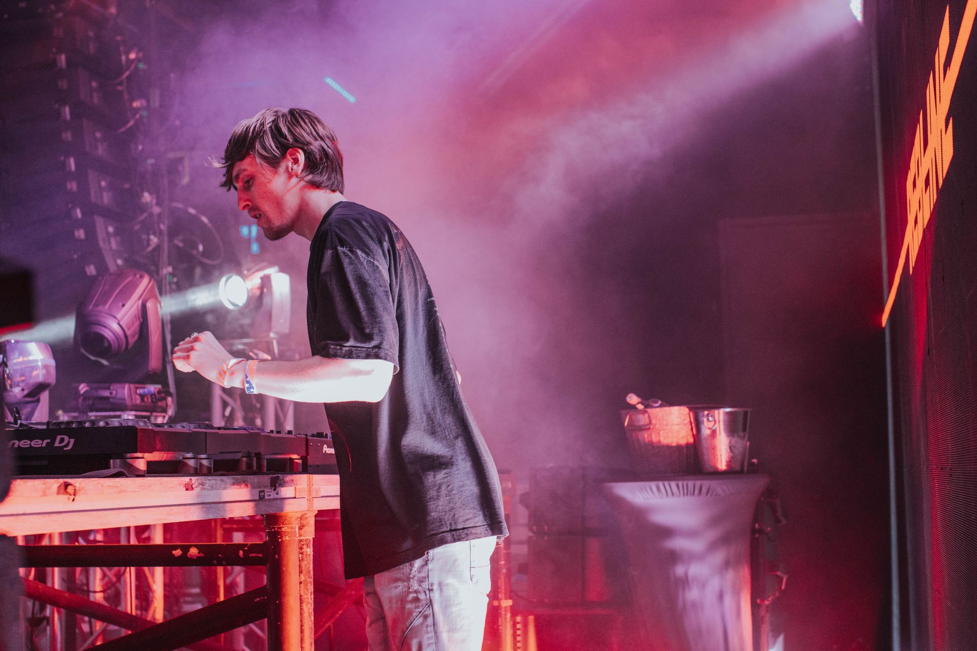 A man is playing a dj set on a stage.